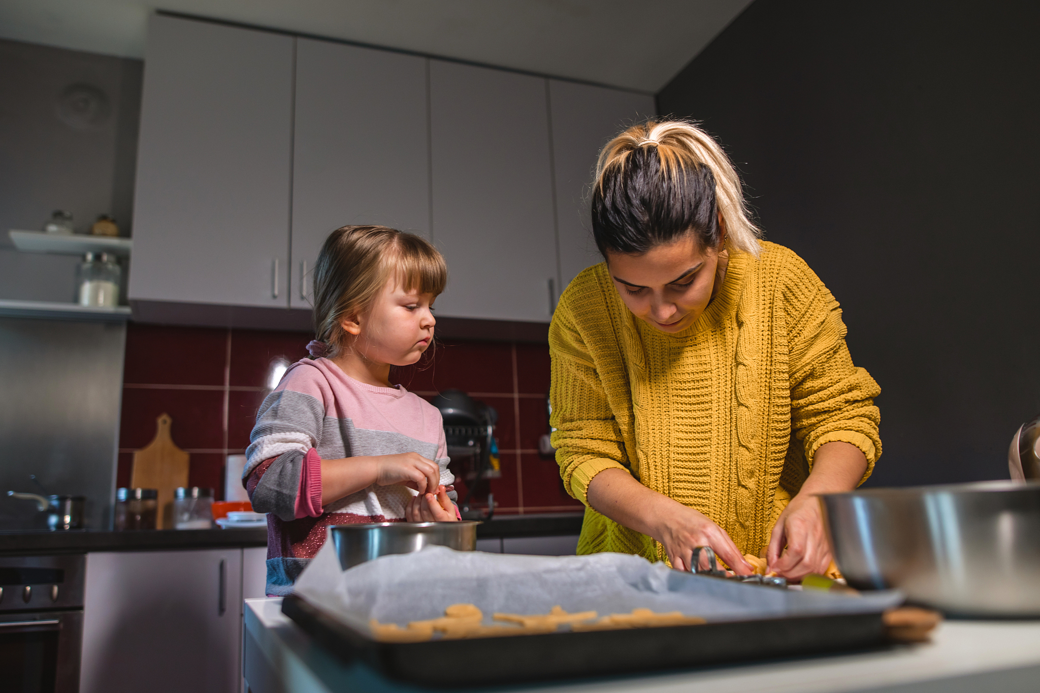 young woman with daughter makes cookies for christmas