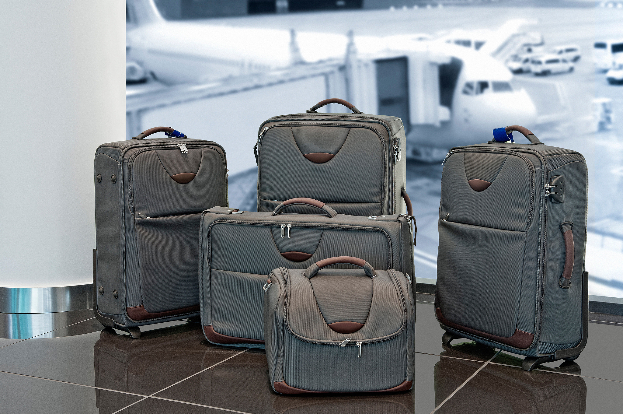 lot of travel luggage set with airplane in background