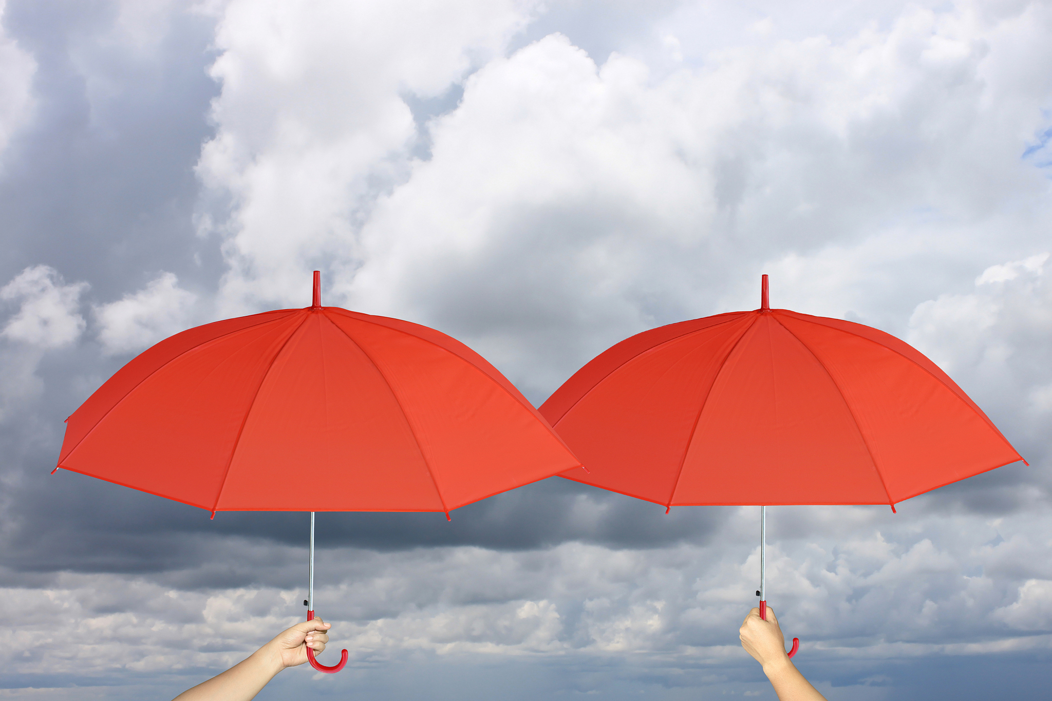 two red umbrella in hand and rain protection,concept for managem