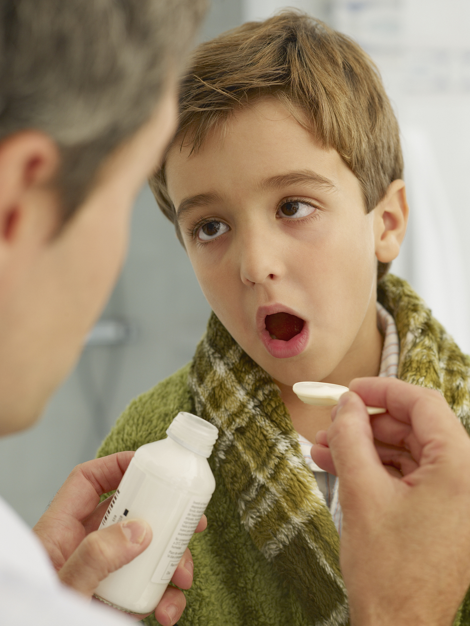 doctor giving young patient medicine