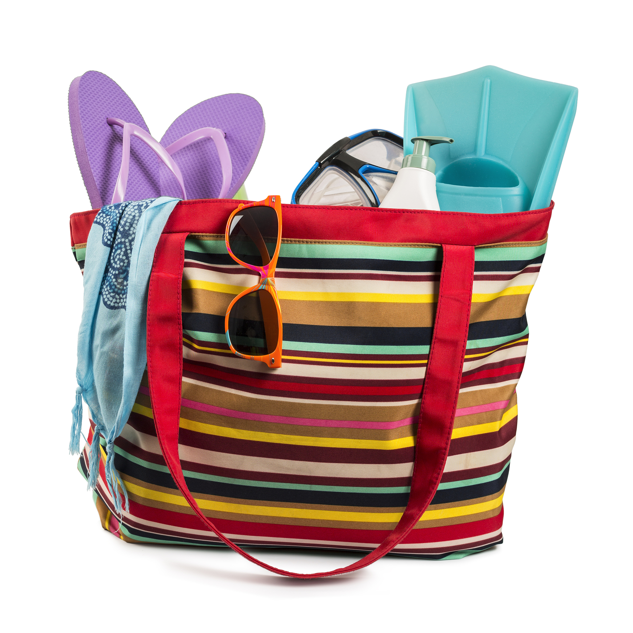 multi colored beach bag with items isolated on white background