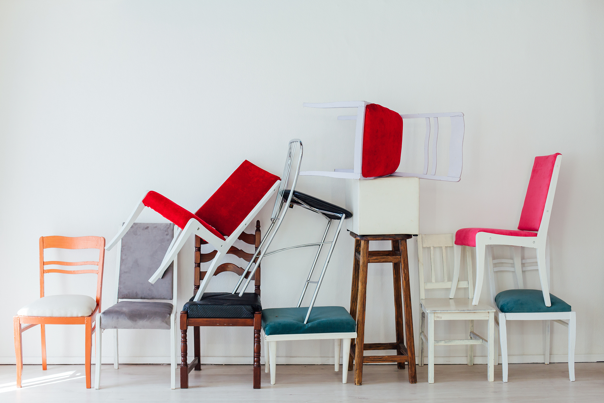 many multicolored chairs in the mess of the white room