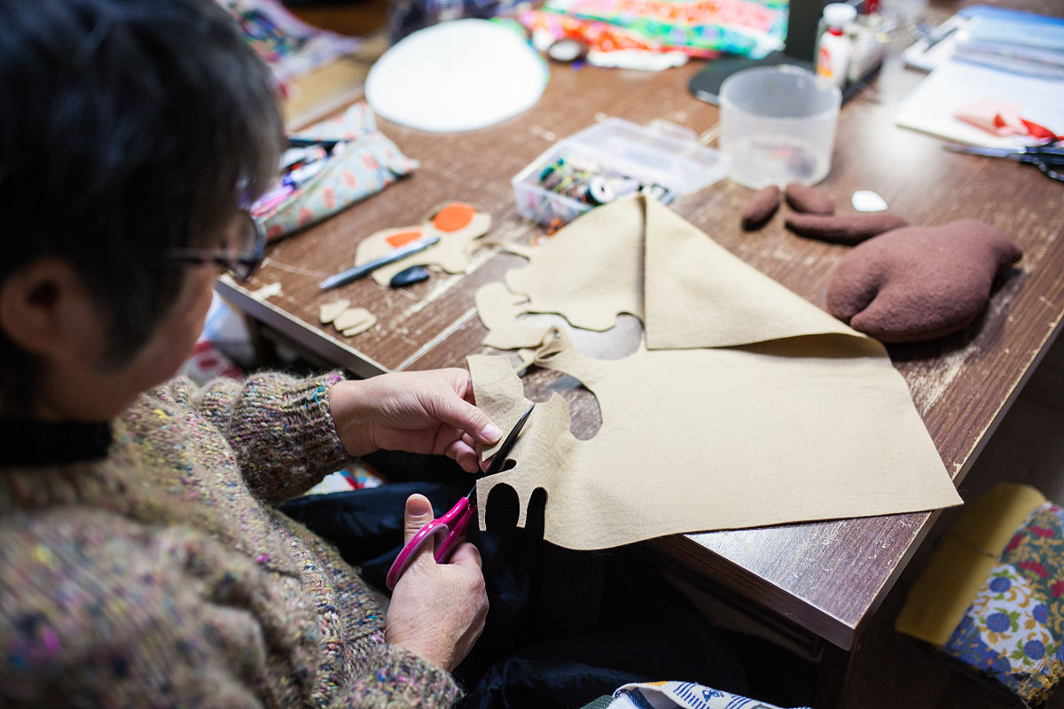 一位年长妇女在她的家中缝纫和制作工艺品