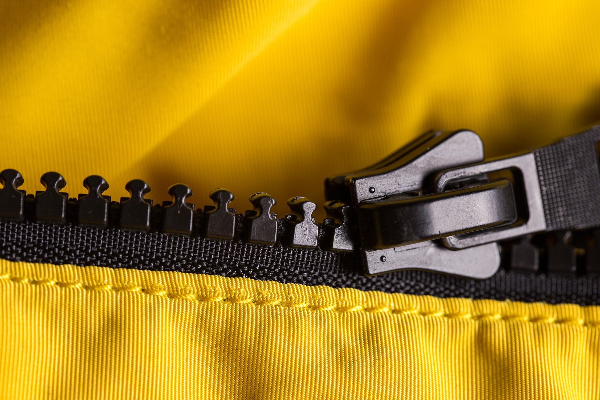 zipper on clothes close-up. black color. bright yellow jacket