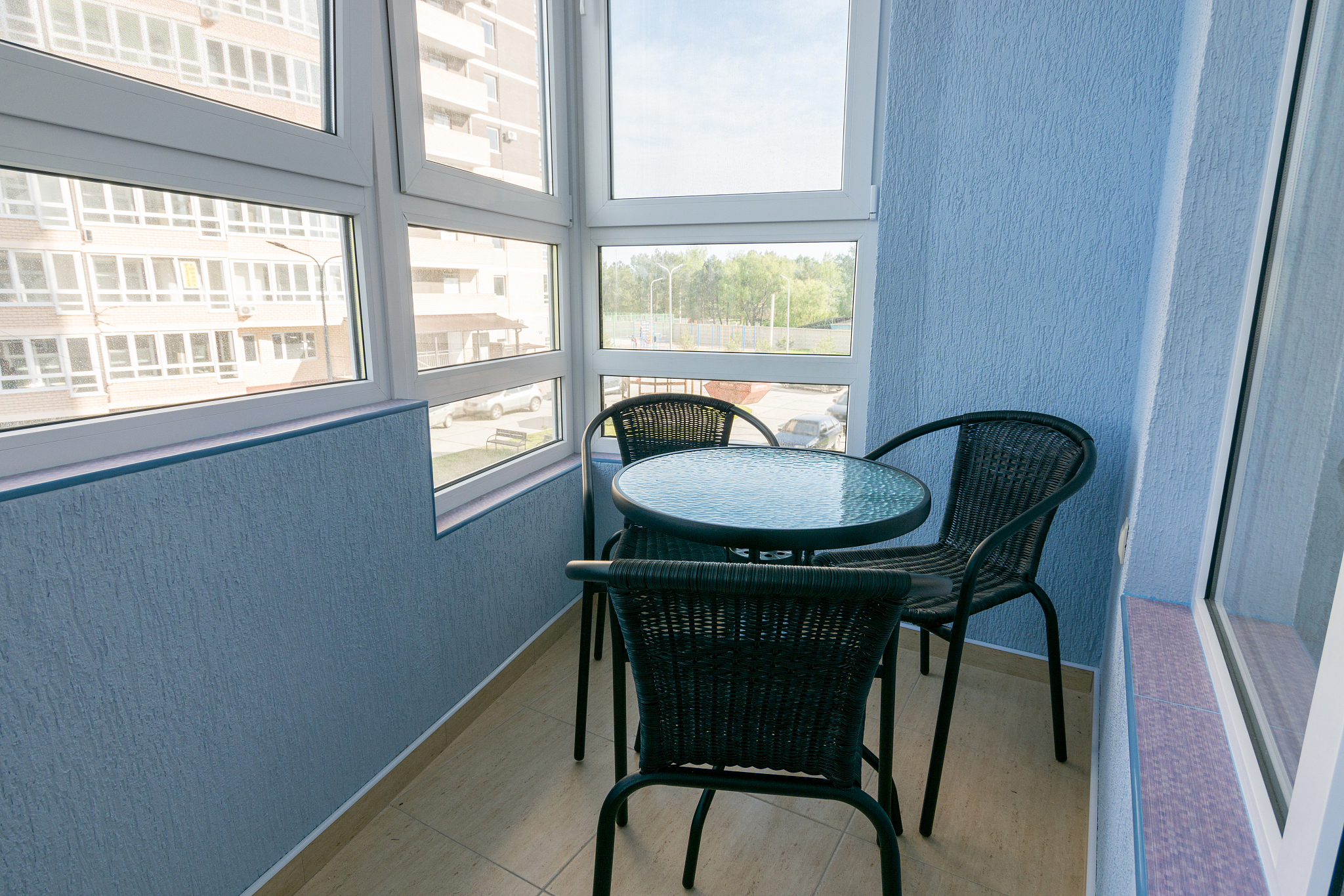 a table and three chairs on the balcony in the apartment of a mu