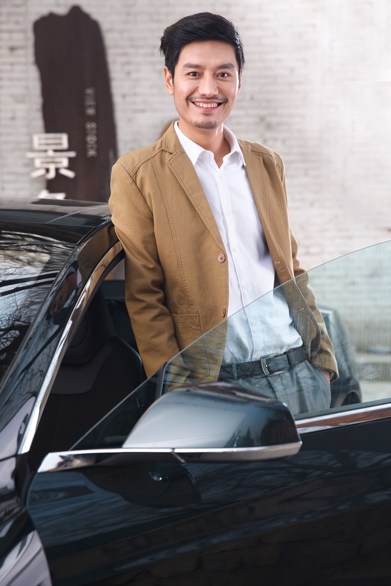 商务男人斜靠在汽车上