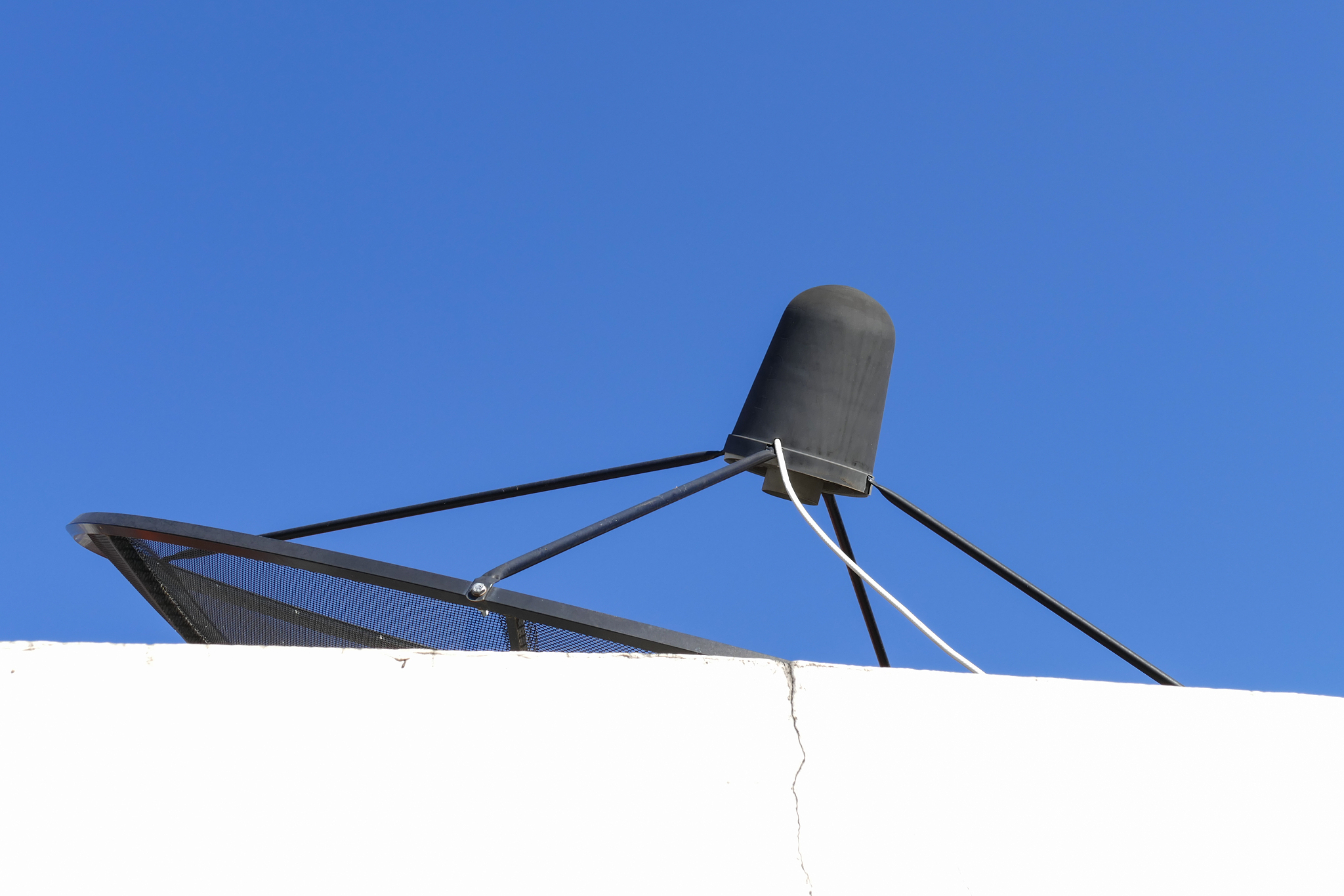 black satellite dish on white building