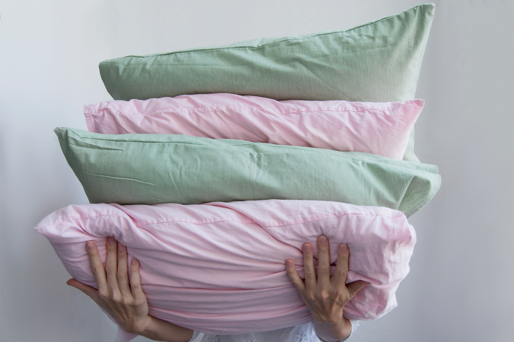 a female hand holds many multi-colored pillows.