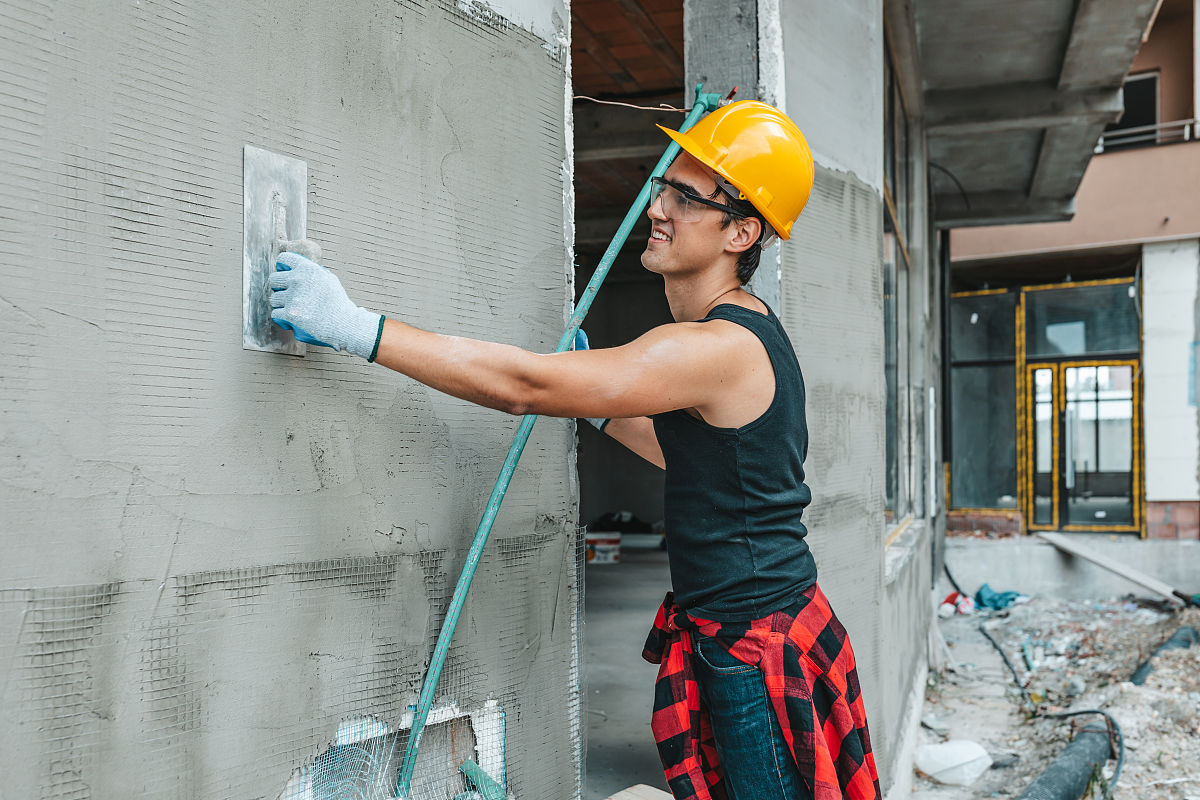 家里装修.建筑工人在房屋外部涂抹装饰灰泥