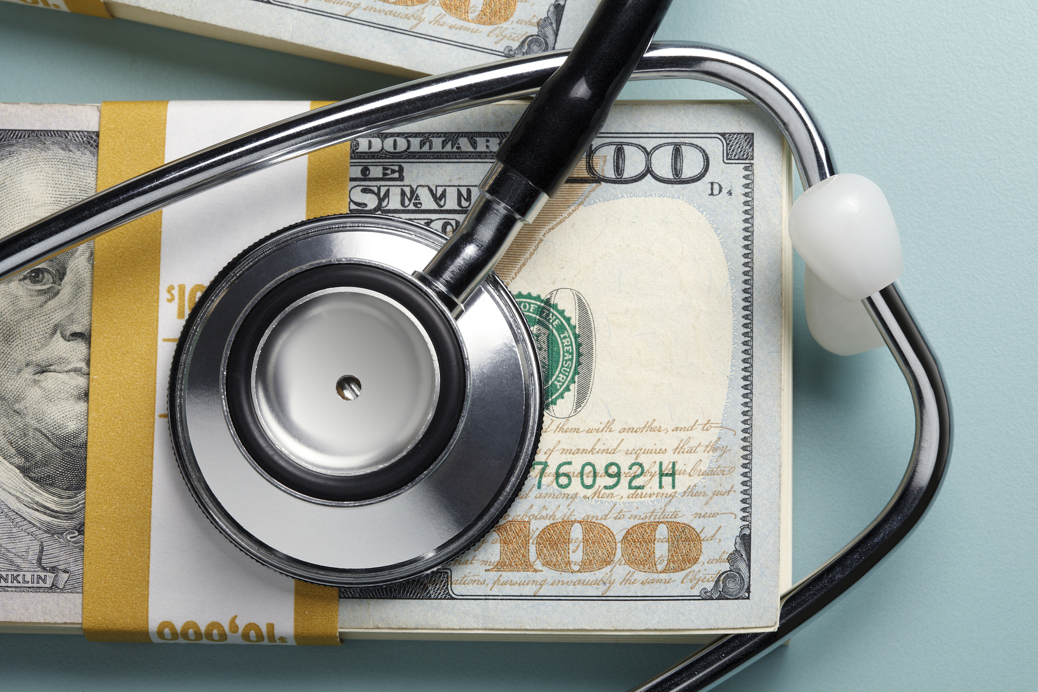 stethoscope on a stack of one hundred dollar bills