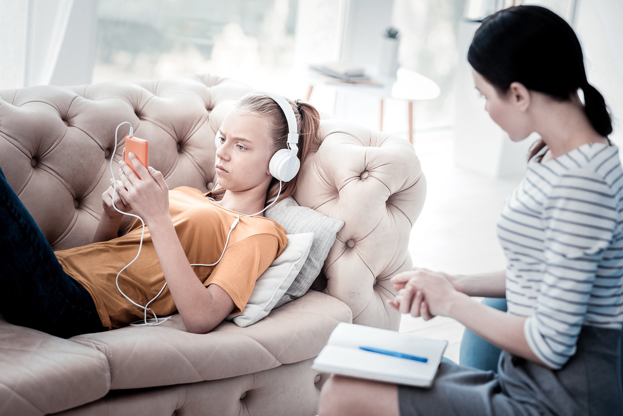 upset girl listening to music during attending psychologist
