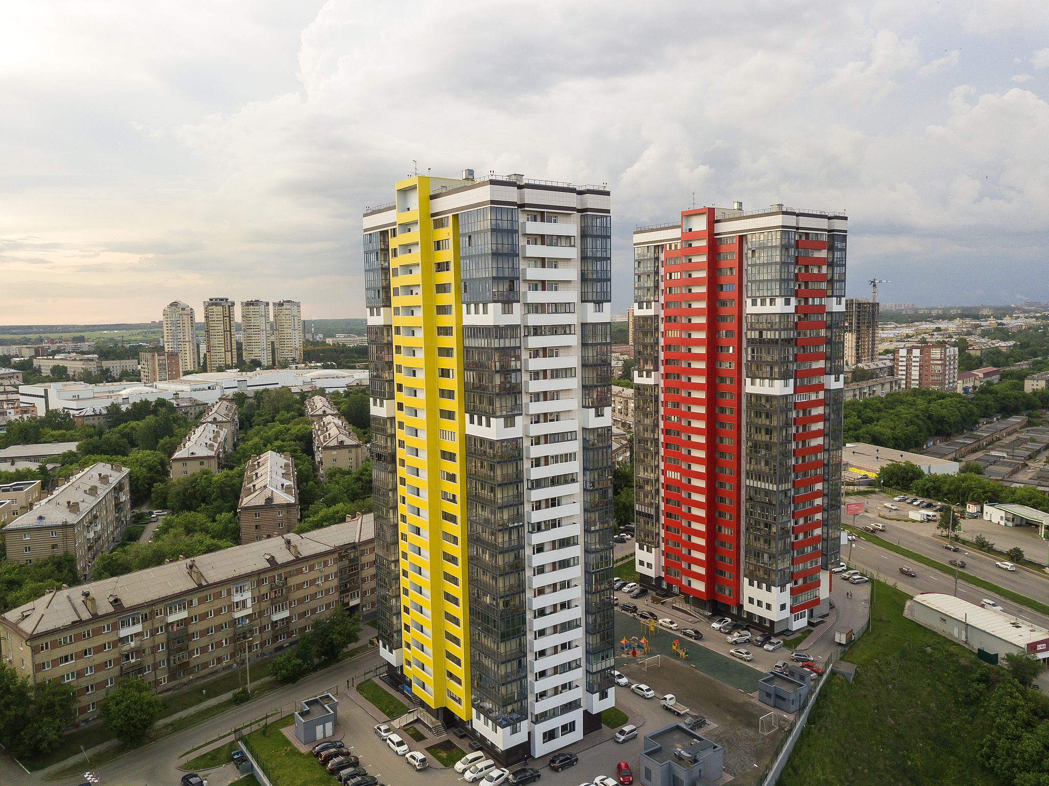 aerial view of landscape with two tall skyscrapers of red and ye