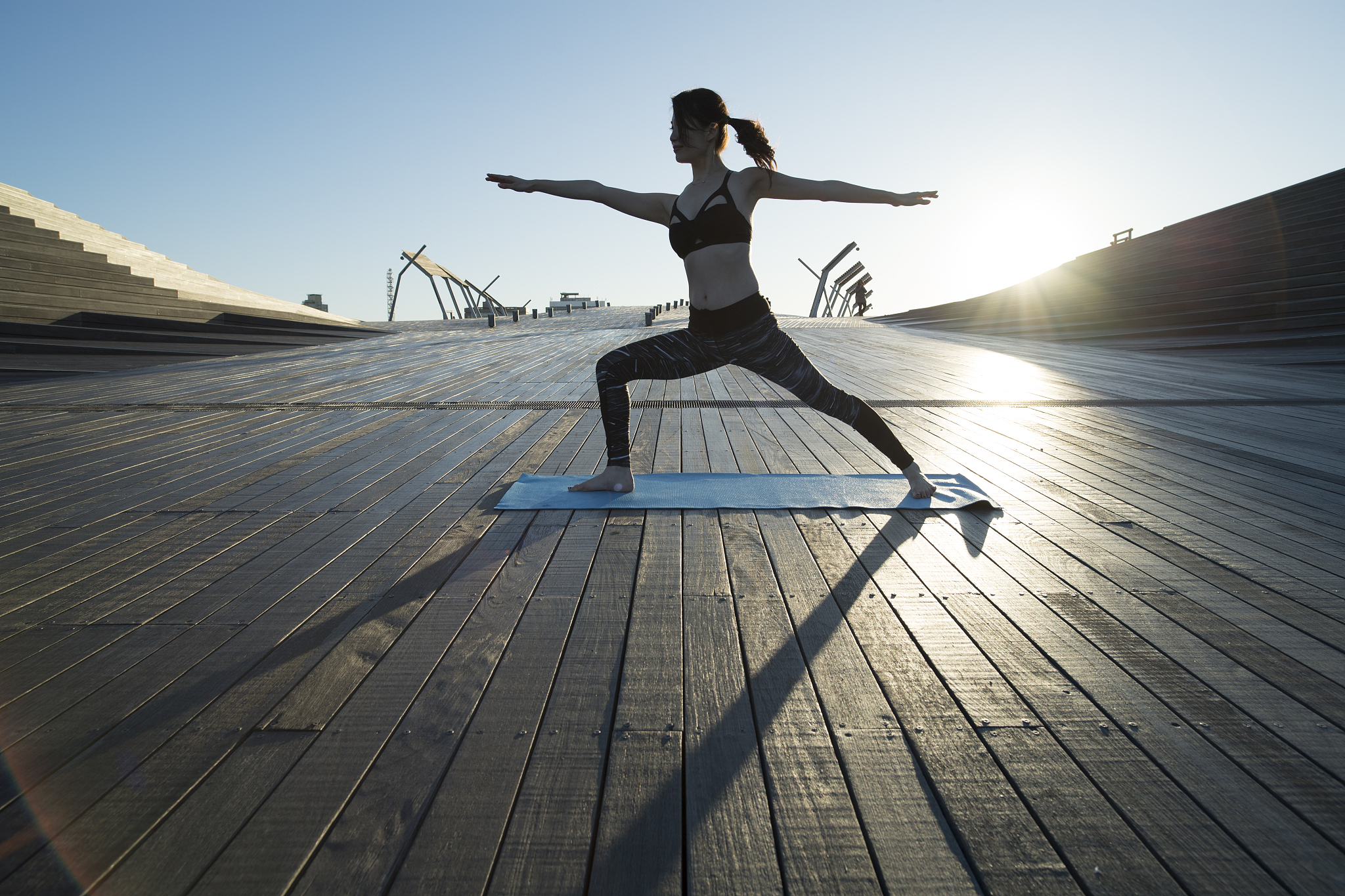 a woman who plays yoga outdoors.
