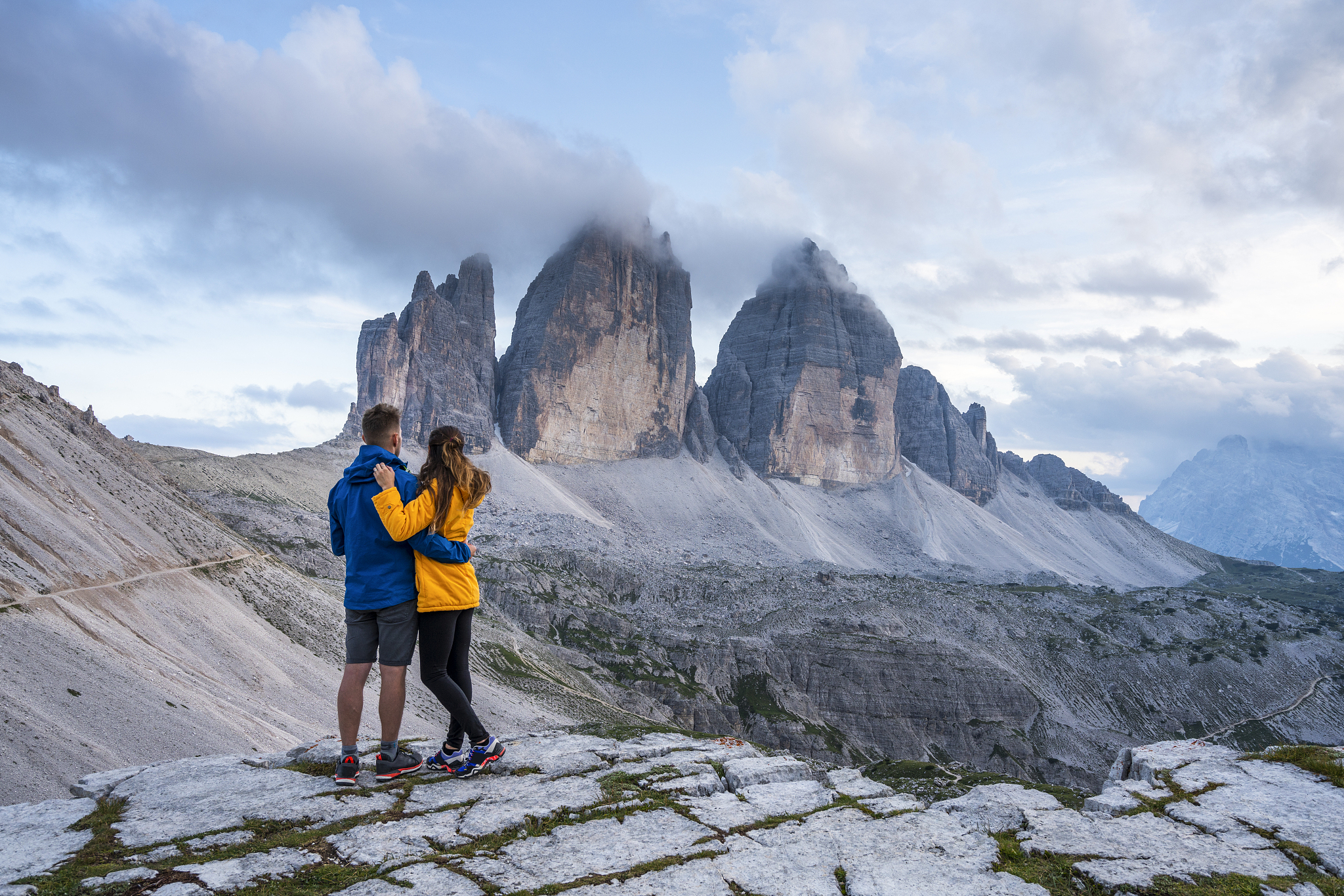 couple admiring the three peaks of lavaredo, italy