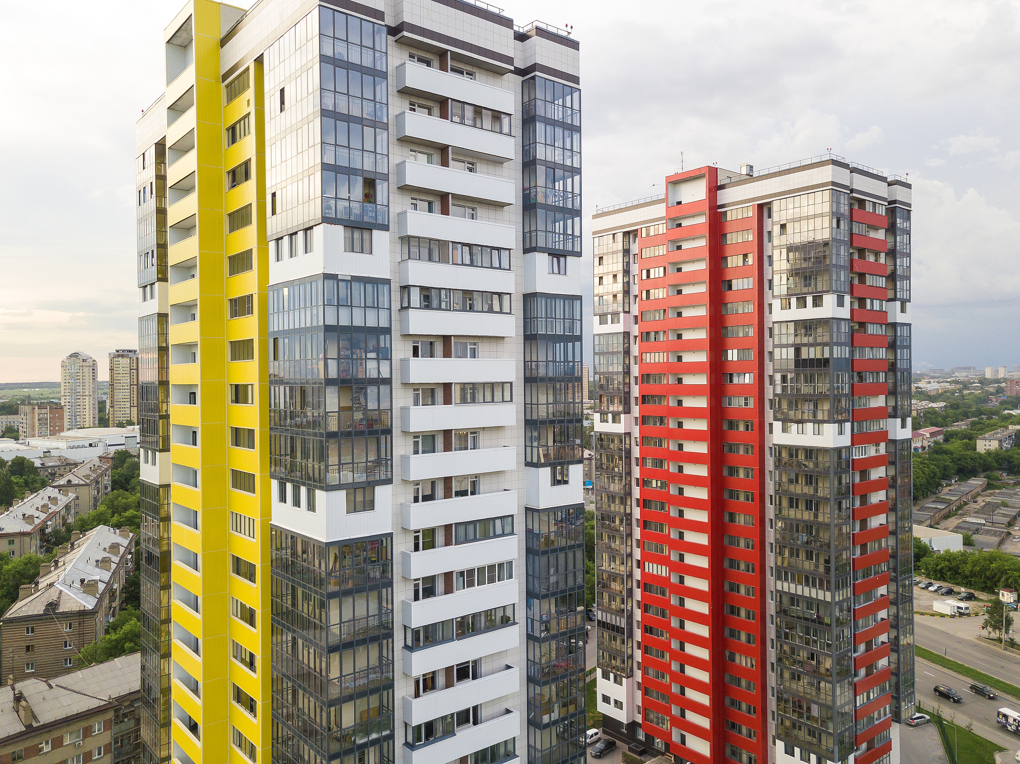 close-up aerial view of two tall skyscrapers of red and yellow c