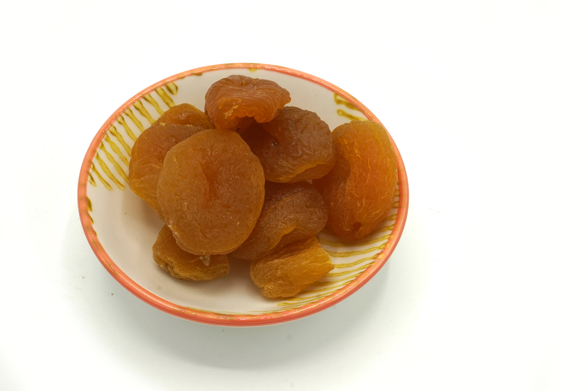 dried apricots on a ceramic saucer isolated on white background.