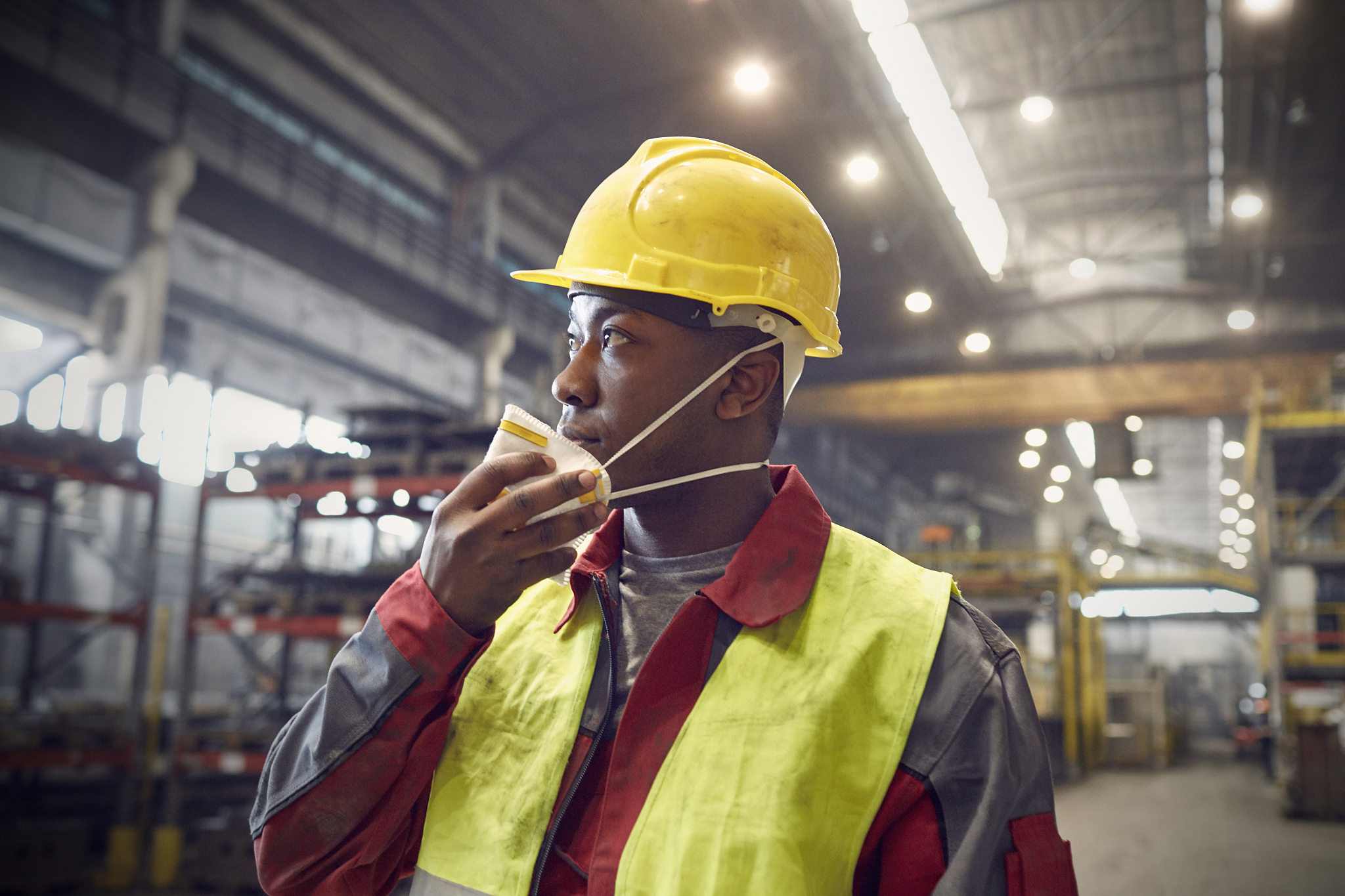 steelworker removing protective mask in steel mill