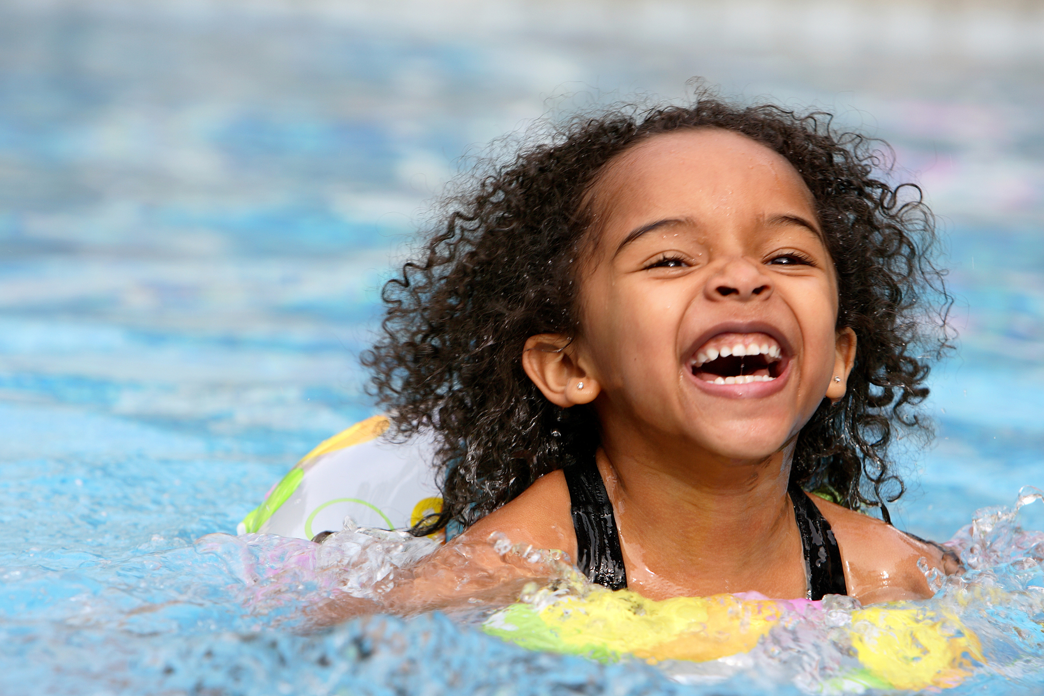 a jubilant kid swimming in a pool