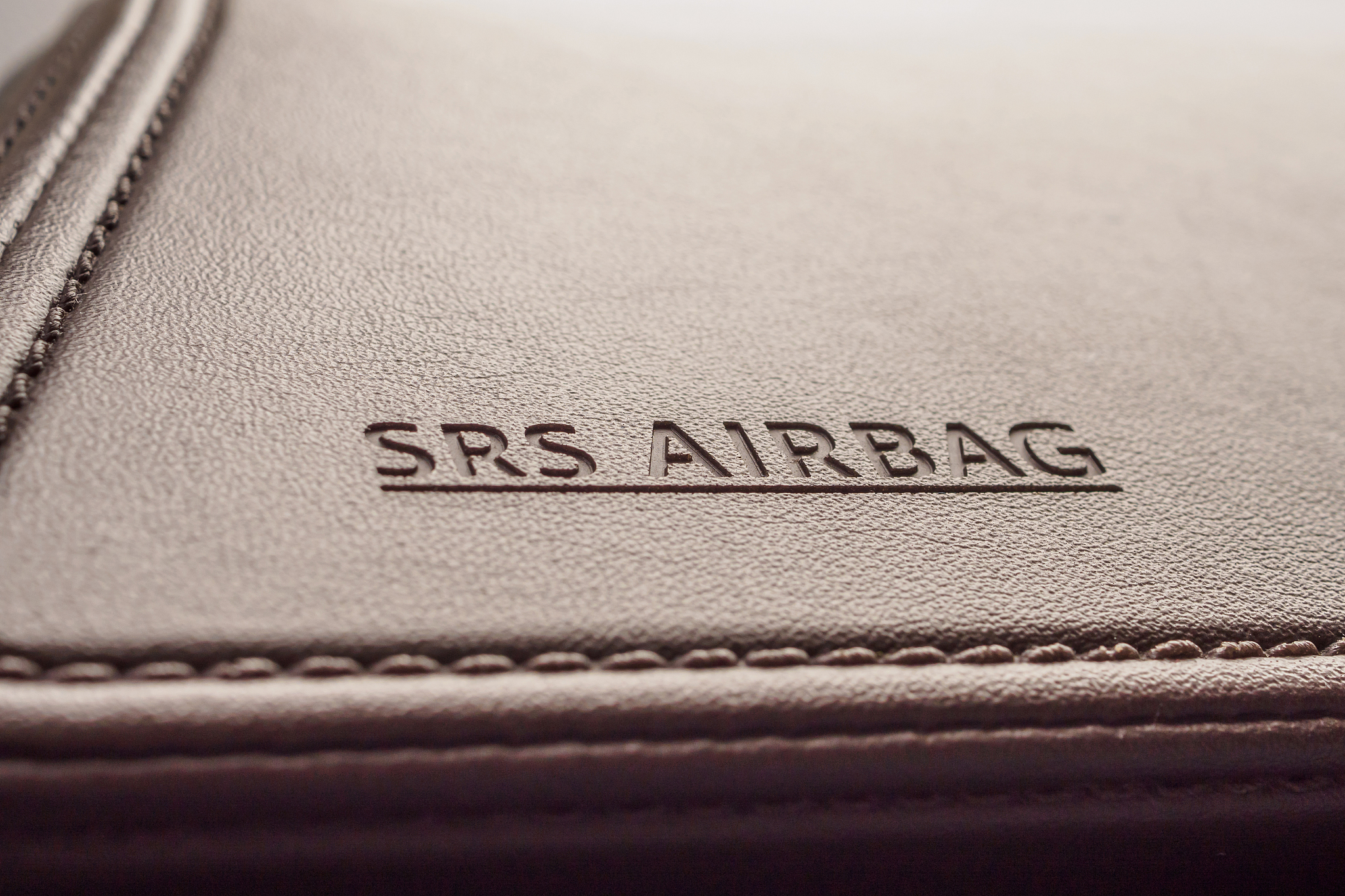 airbag safety sign on brown leather texture in modern car