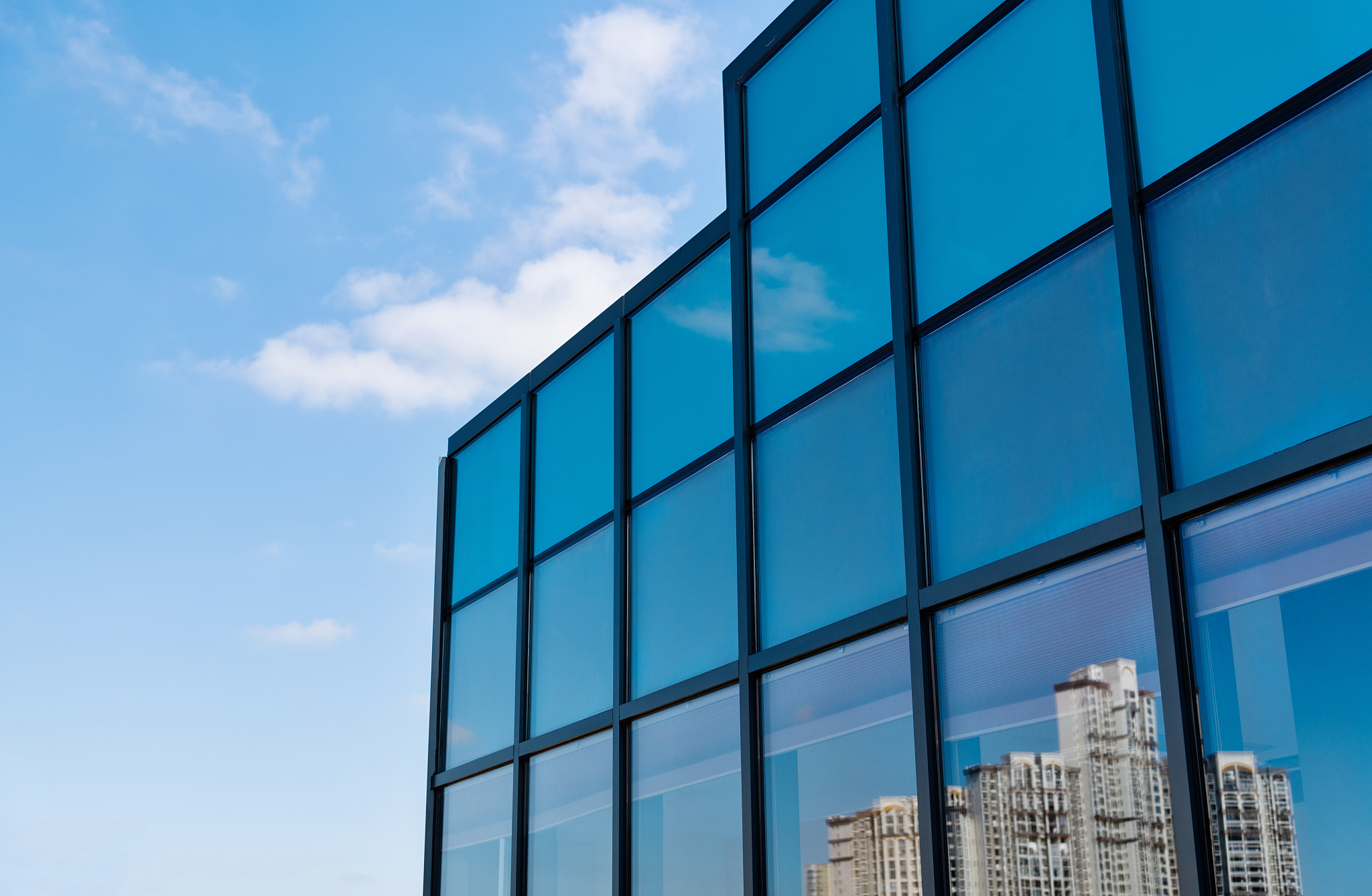 crowded apartment reflected on glass windows of modern building