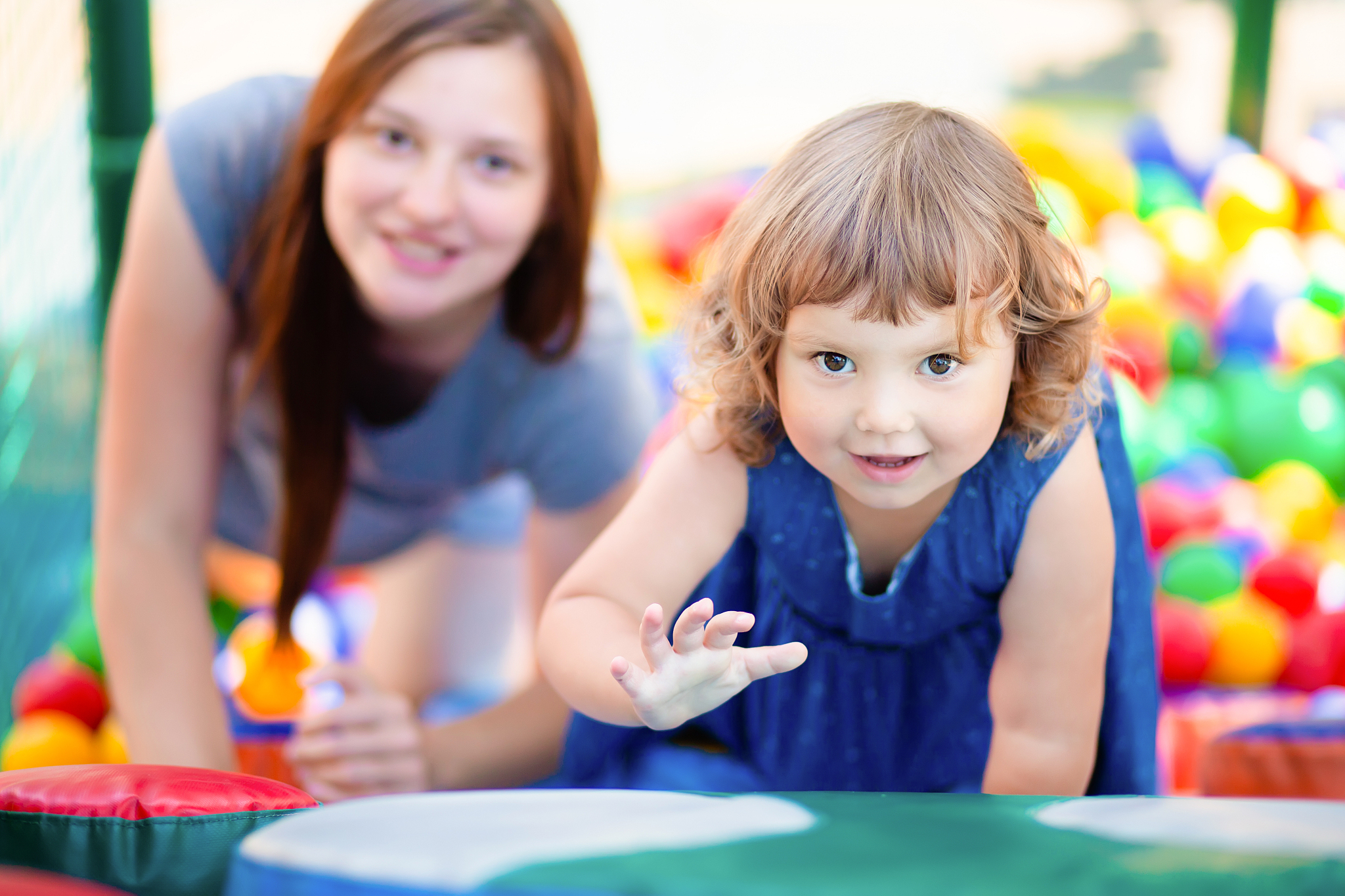 happy little girl having fun in colourful plastic balls pool wit
