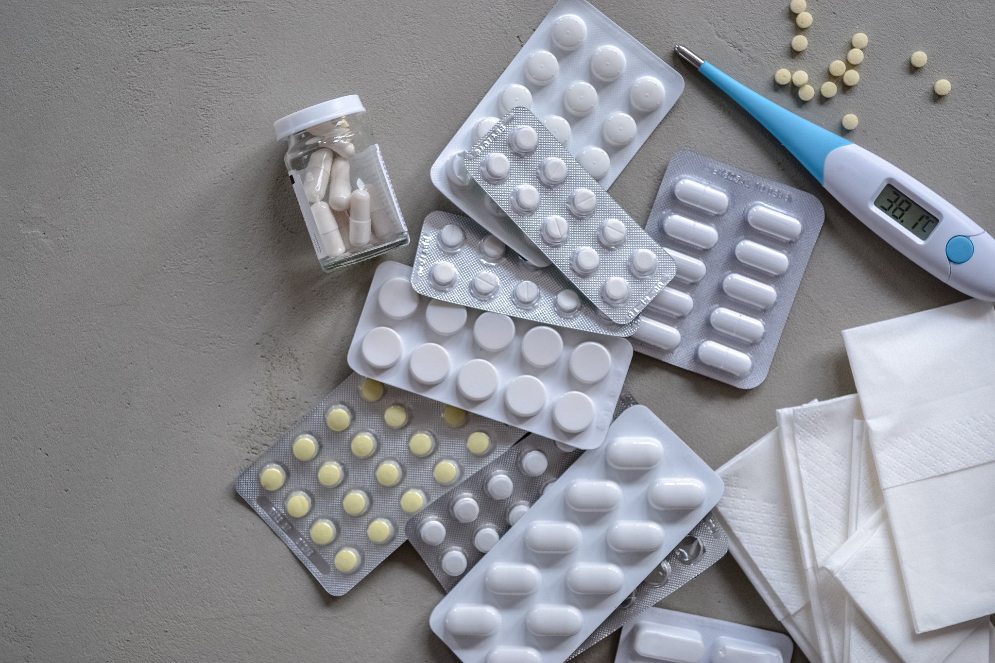 different kinds of pills and tablets, thermometer and napkins