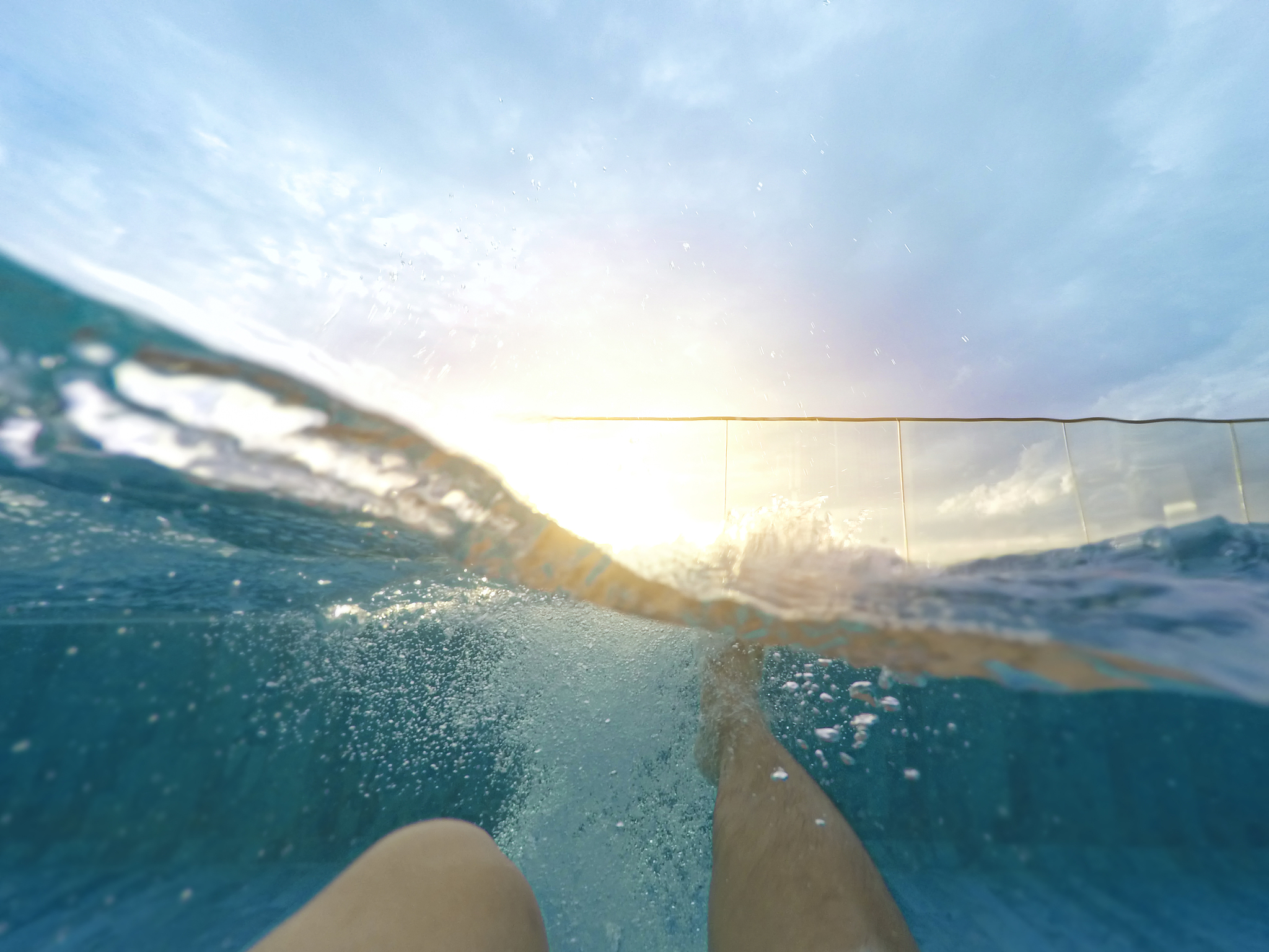 a young woman is swimming which the picture is taken underwater 