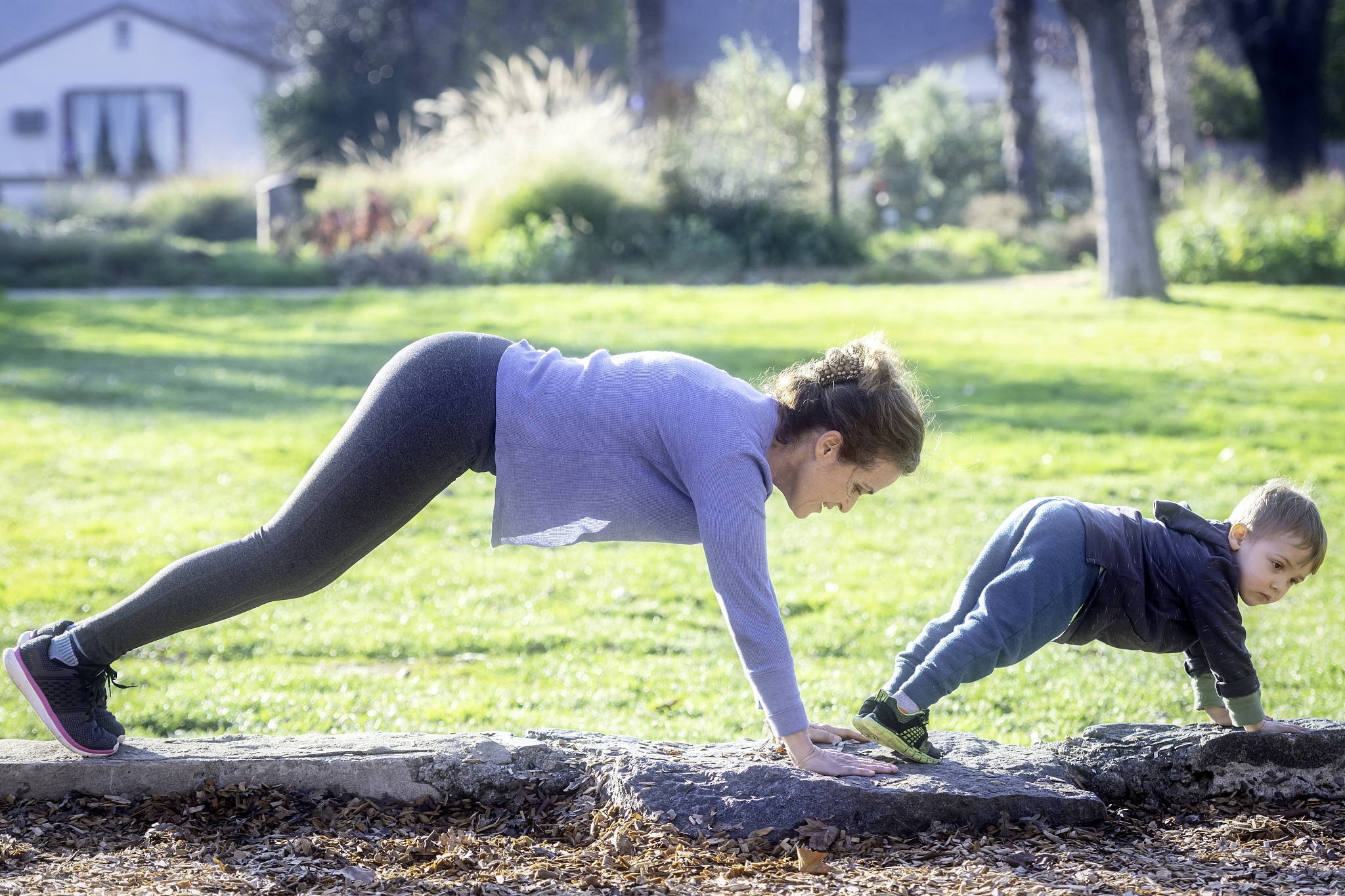 mature woman practicing yoga with her toddler son