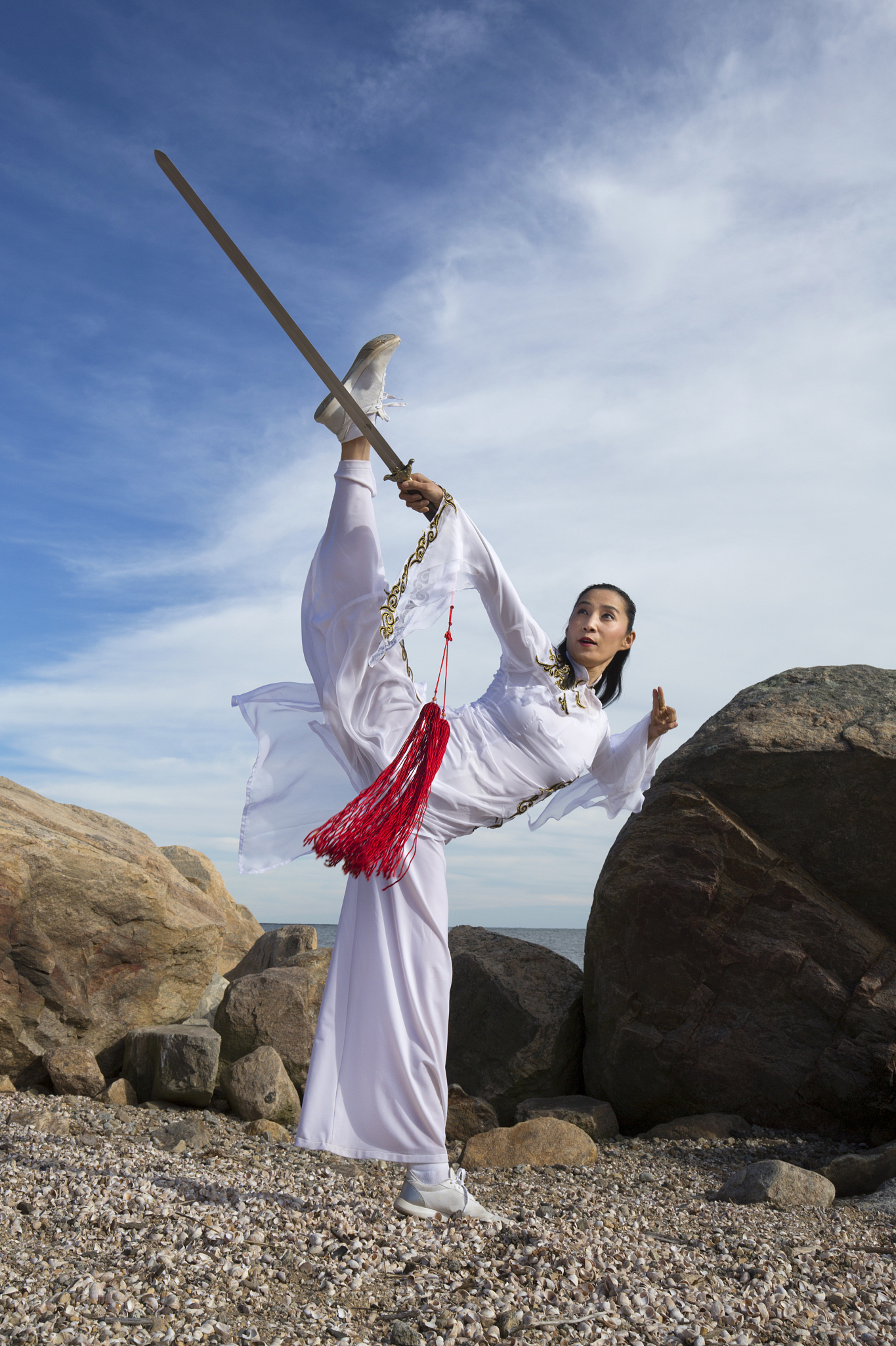 young woman dancer with a sword on a connecticut beach.