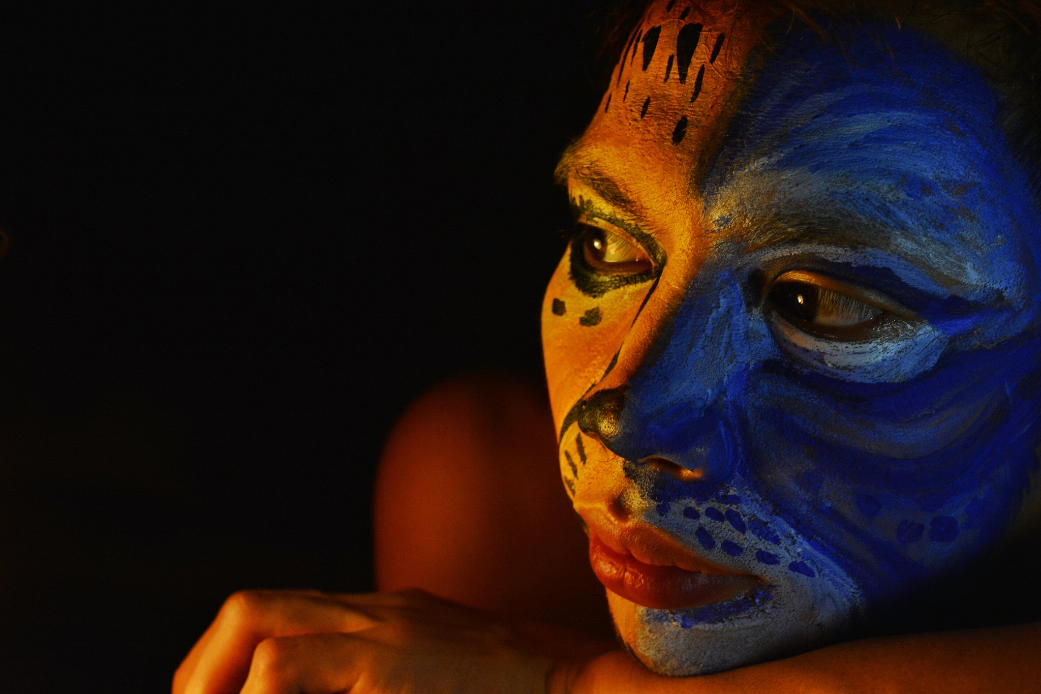 close-up of person with face paint against black background