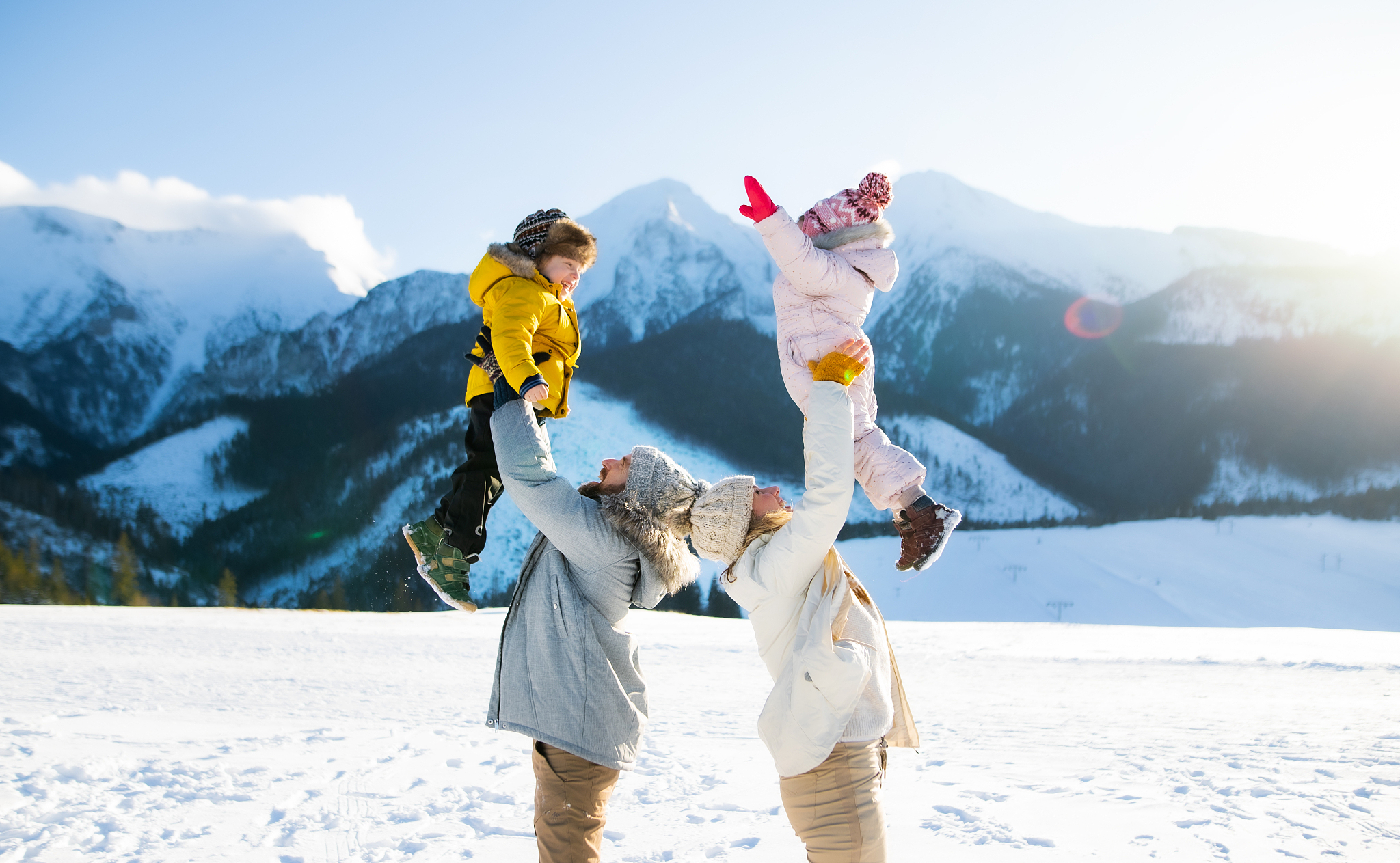 portrait of family with two small children enjoying snow in wint