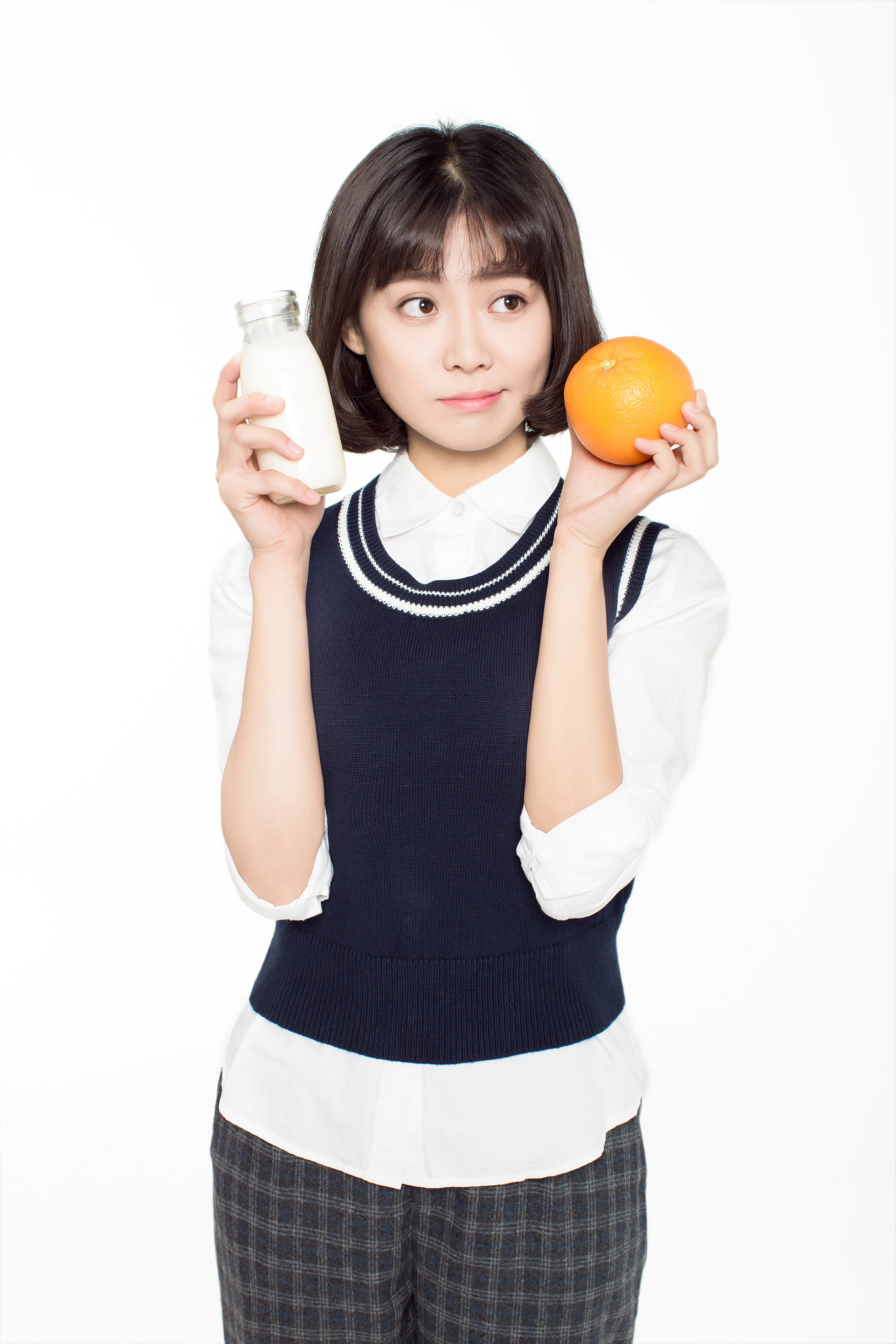 chinese girl and her breakfast, a glass of milk and an orange