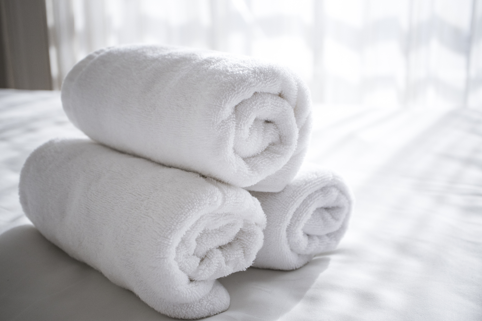 sun lights to the clean white towels on the hotel bed : feels co