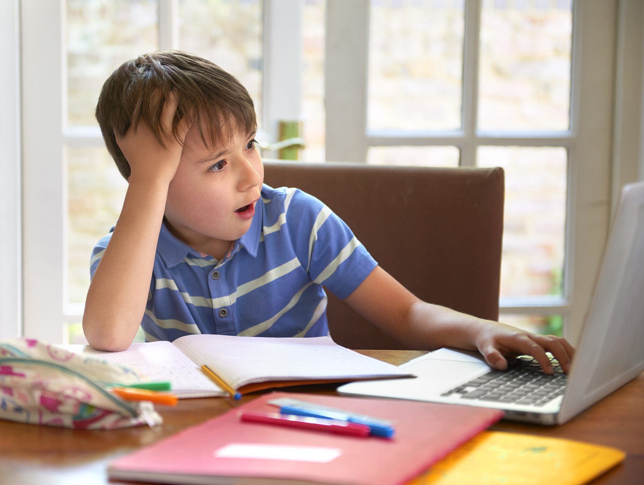 boy distracted chatting on computer from home
