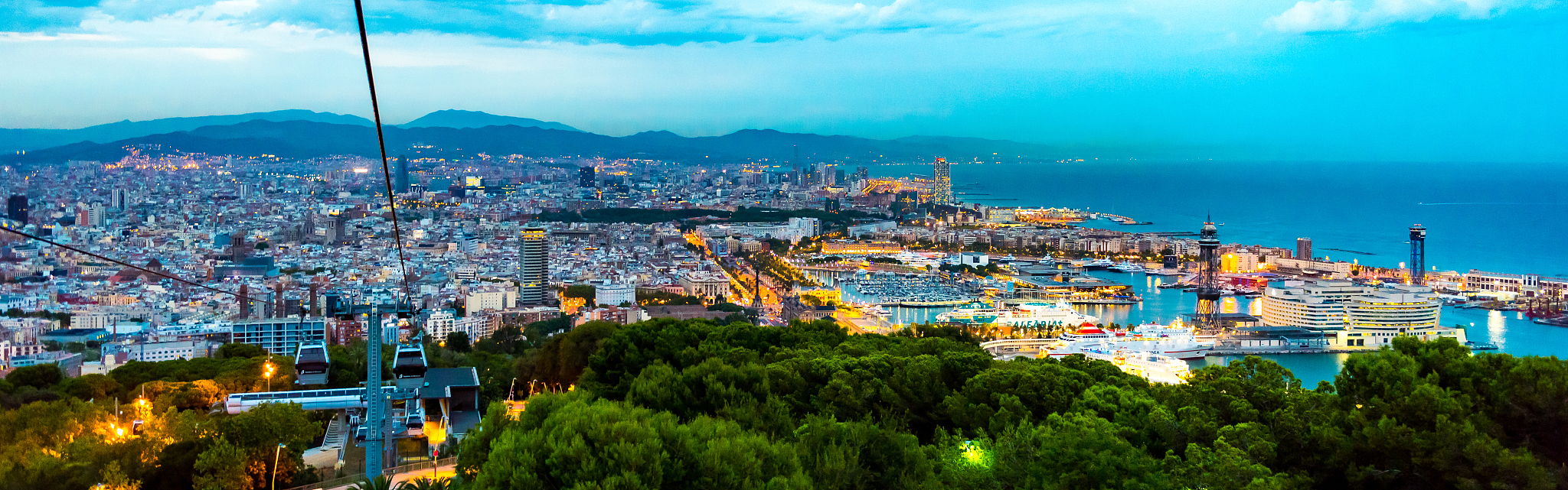 high angle view of illuminated cityscape by sea against sky