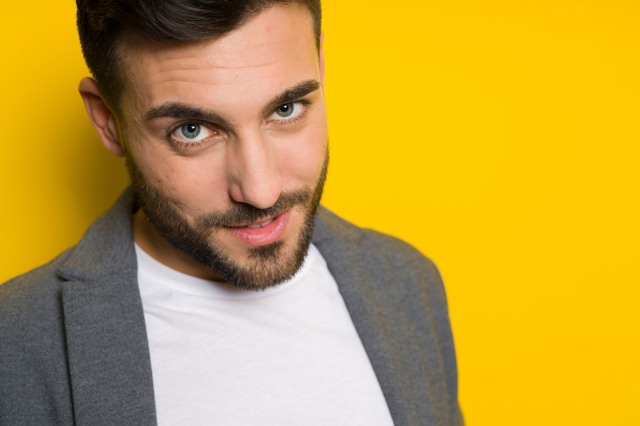 young handsome man possing and modeling over yellow isolated bac