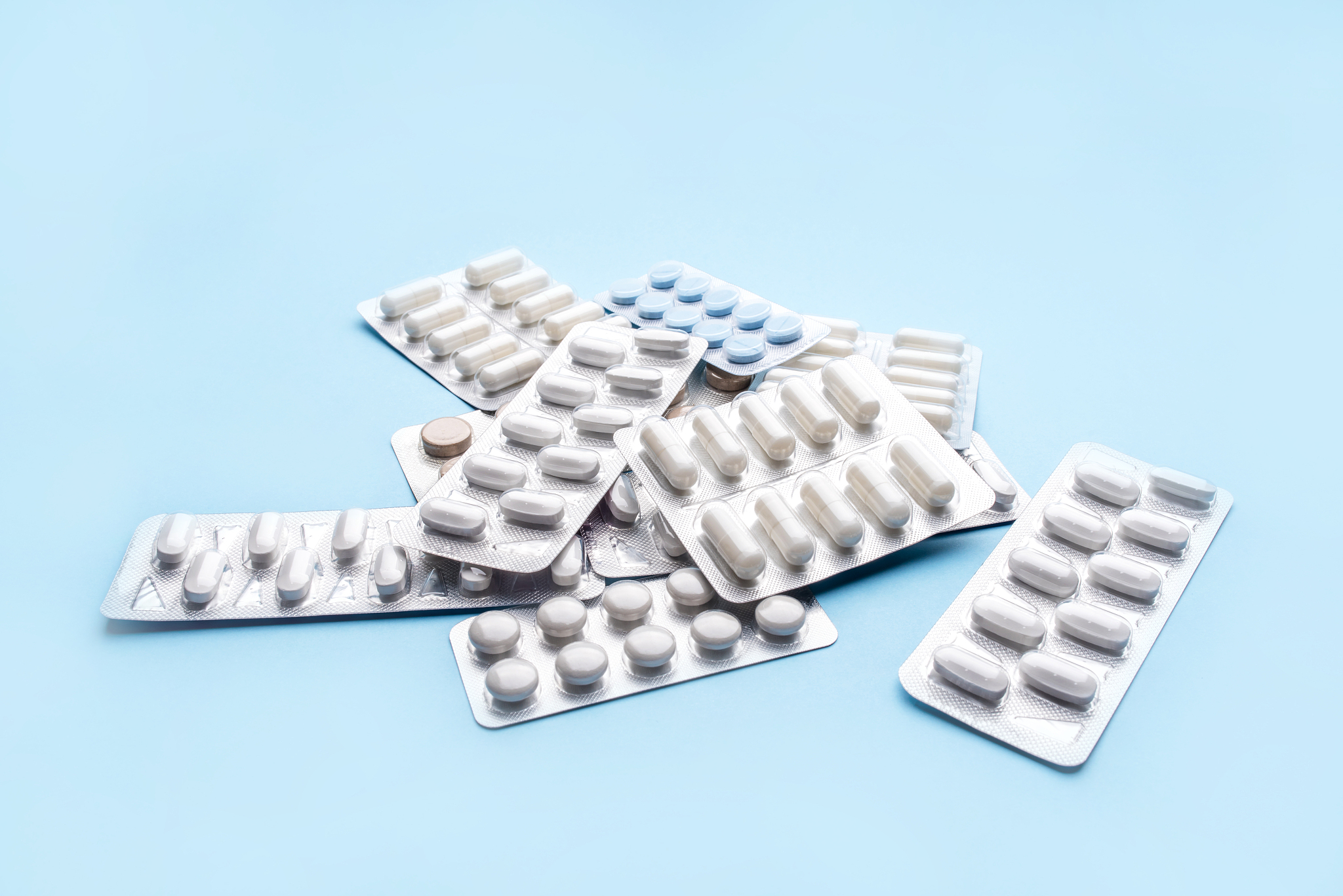 pills in blister packs on blue background.