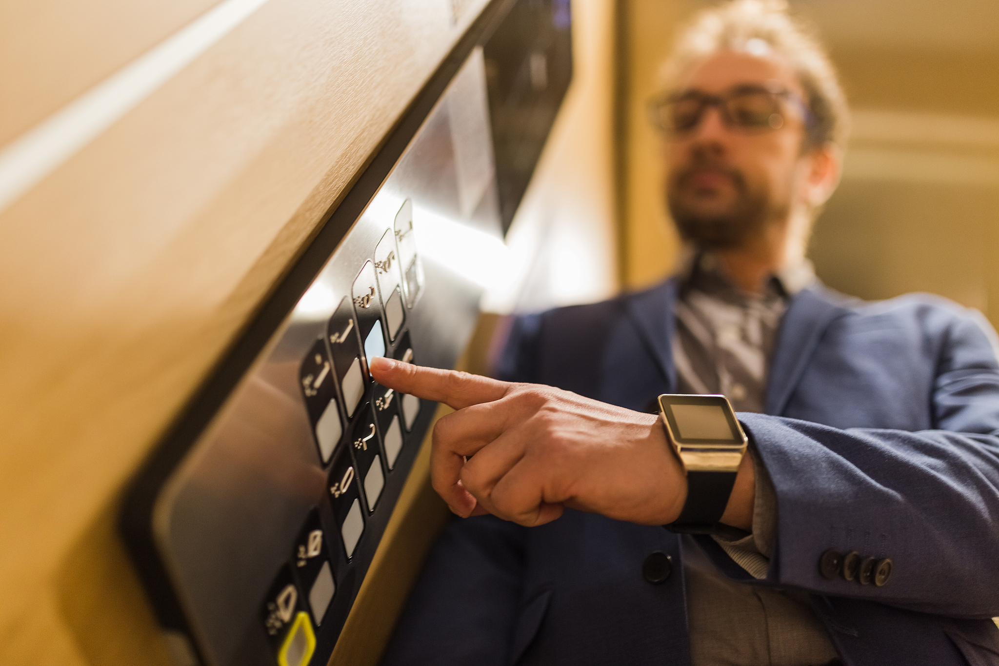 close up of businessman pressing third floor control panel butto