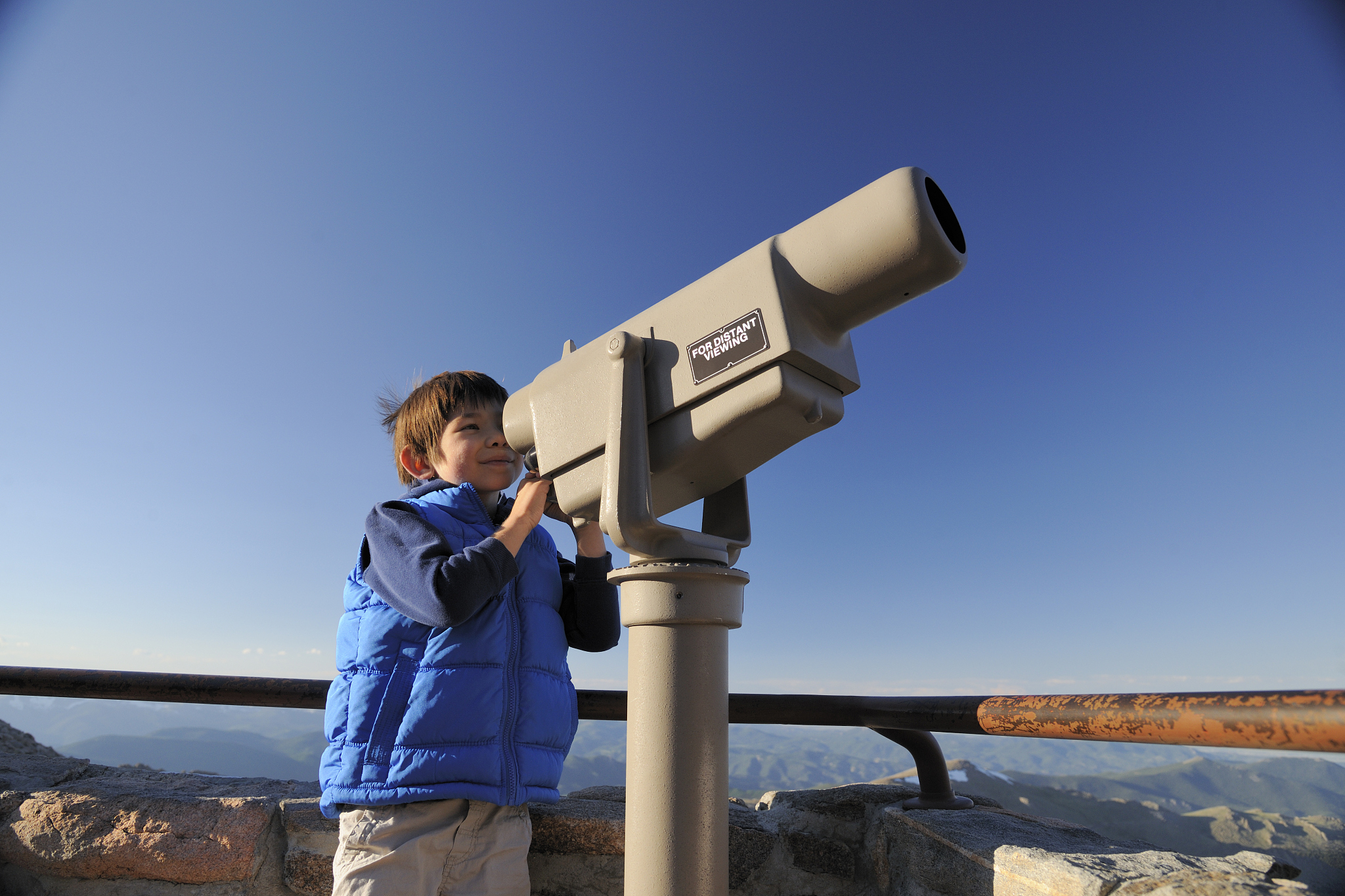 young boy looking through scenic telescope