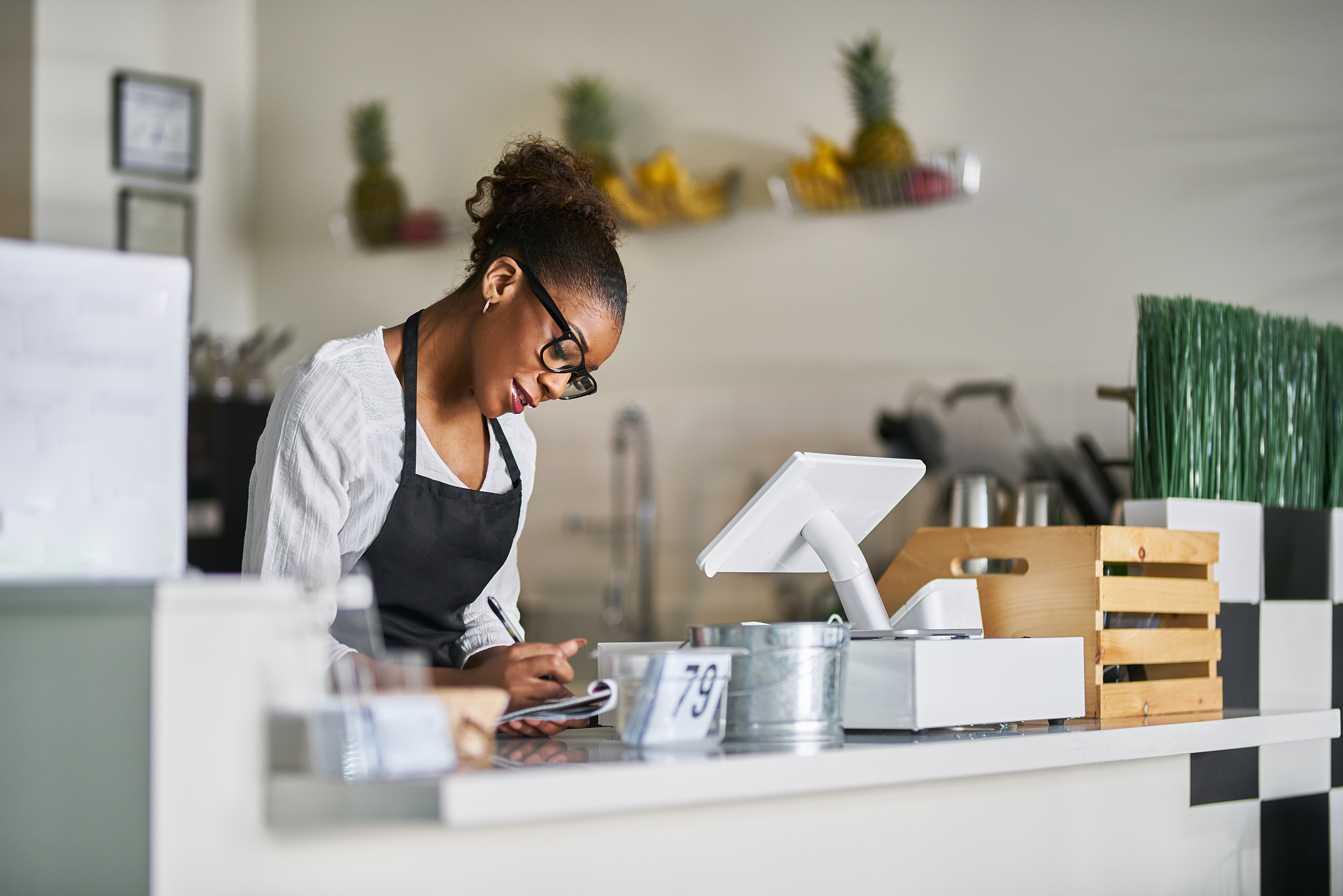 shop assistant taking order on notepad at restaurant counter