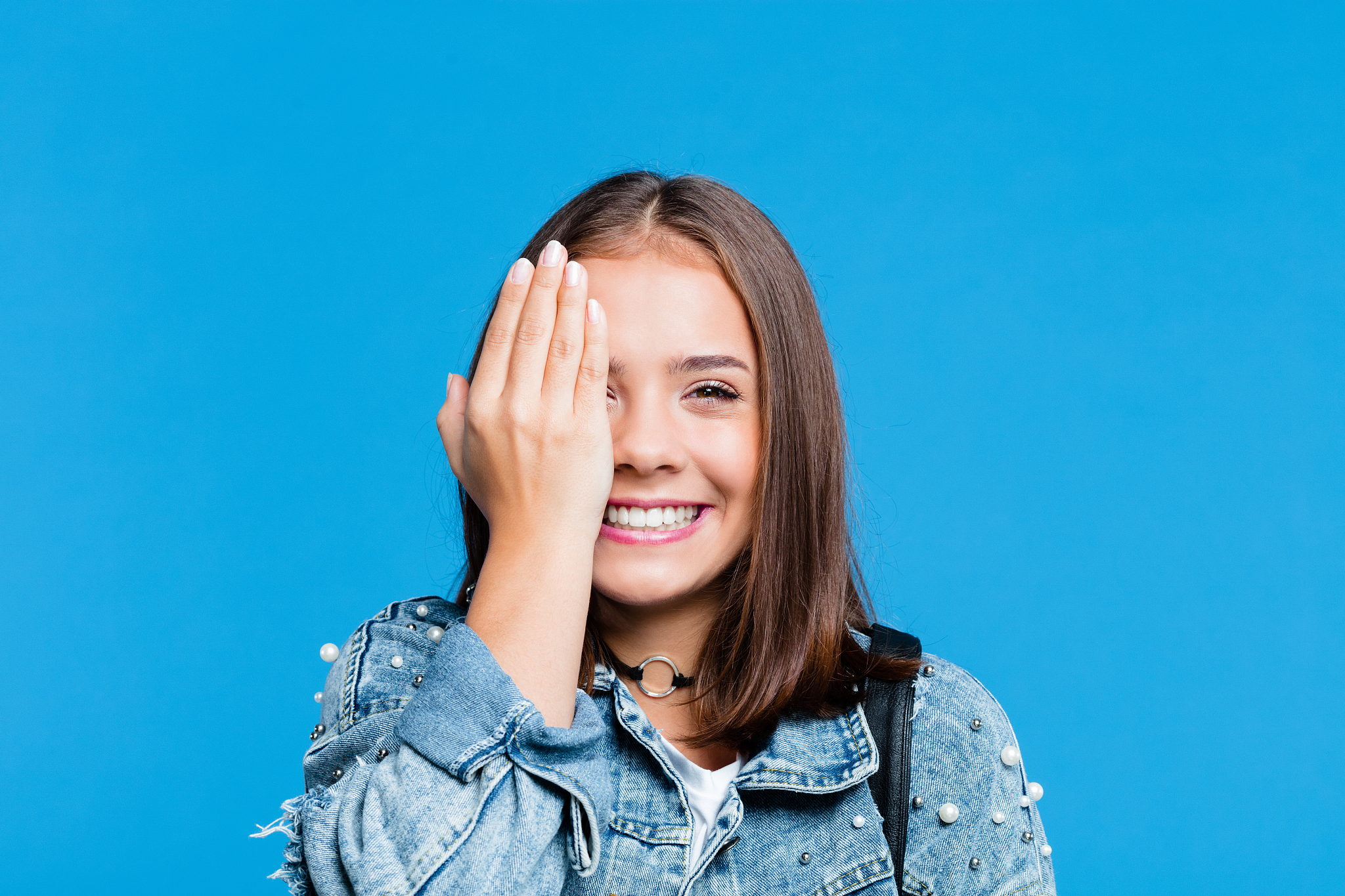 cheerful pretty teenege girl on blue background