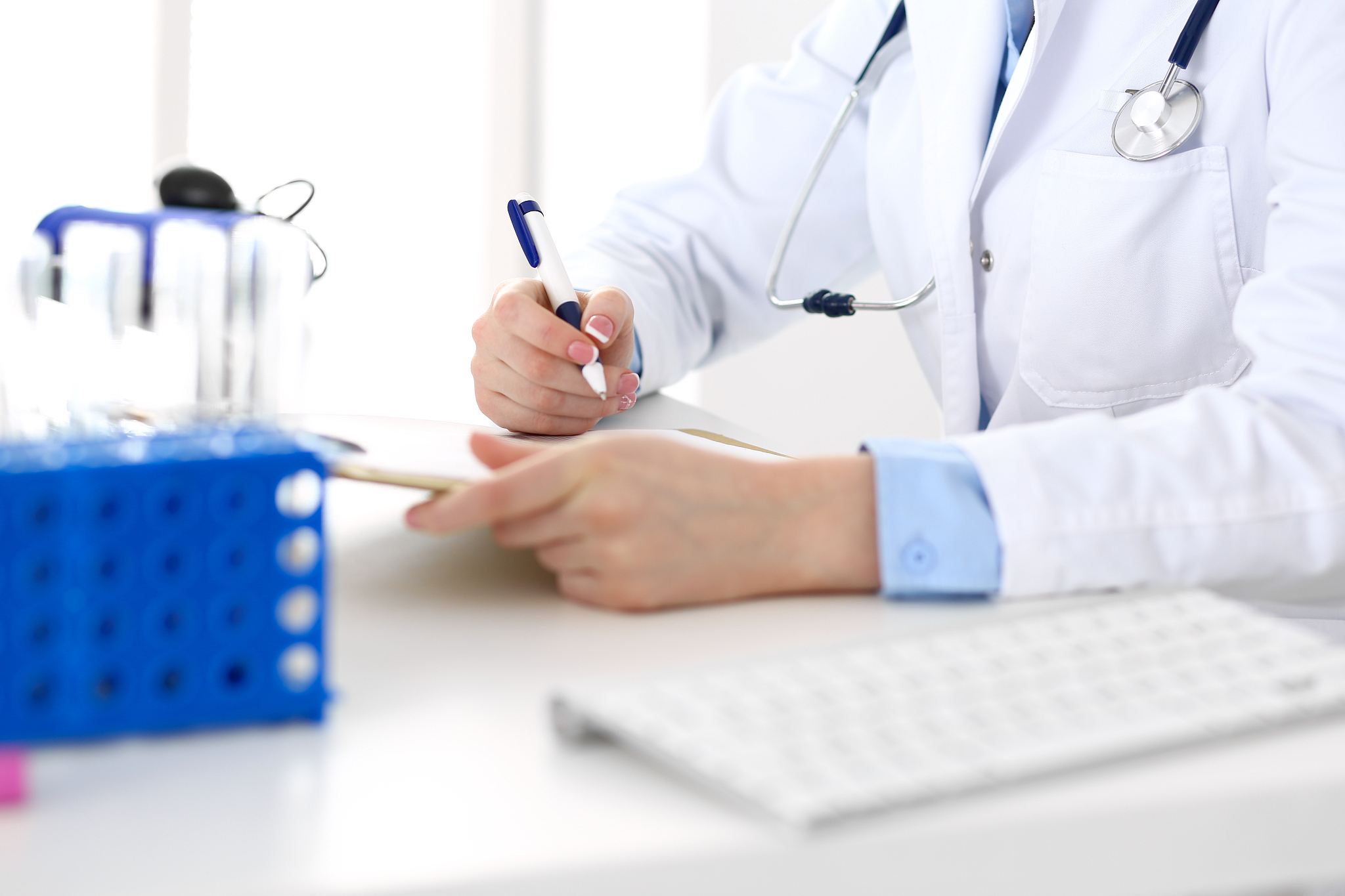female doctor filling up medical form on clipboard closeup.  phy