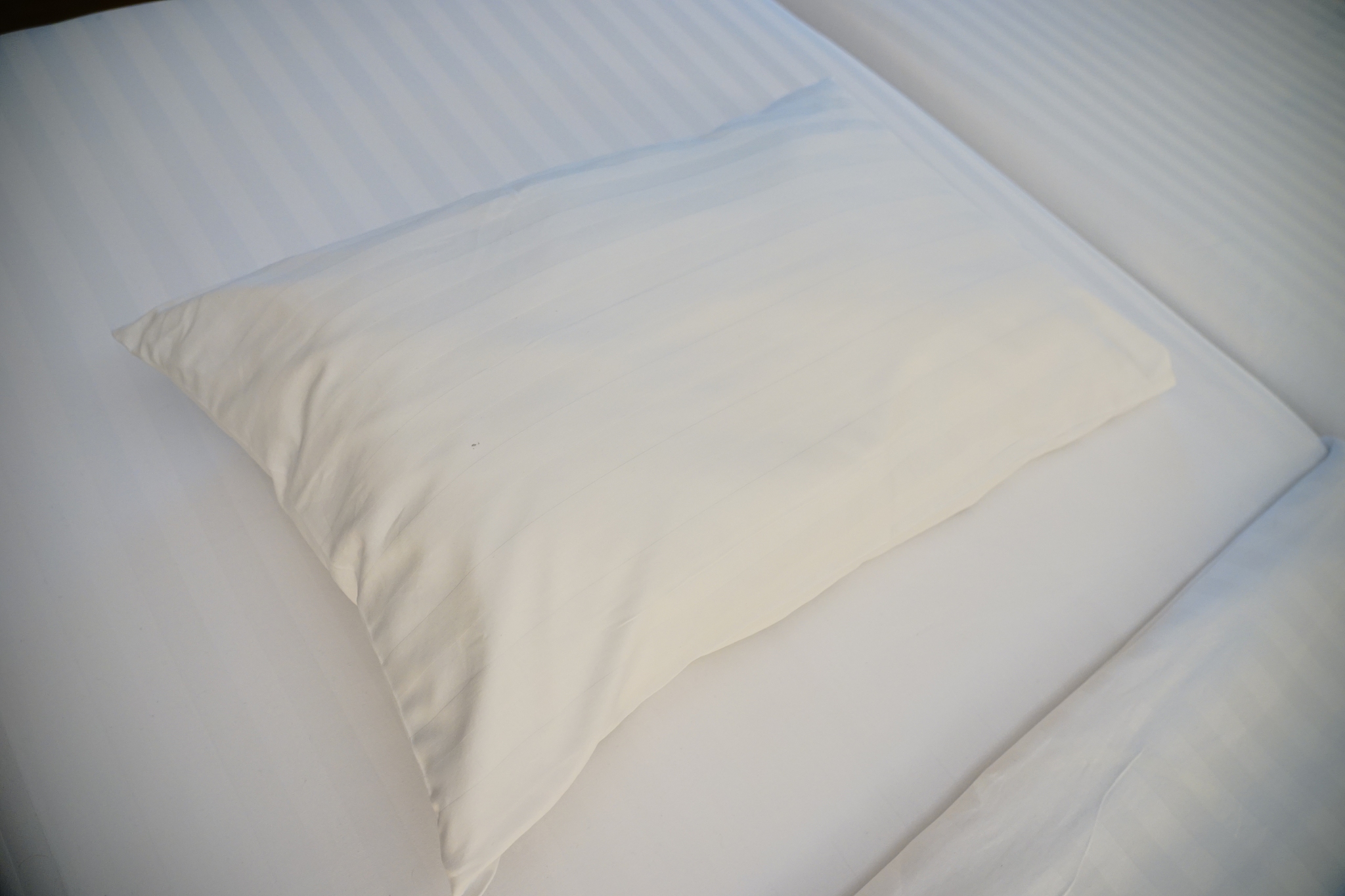white pillow with blanket on bed unmade
