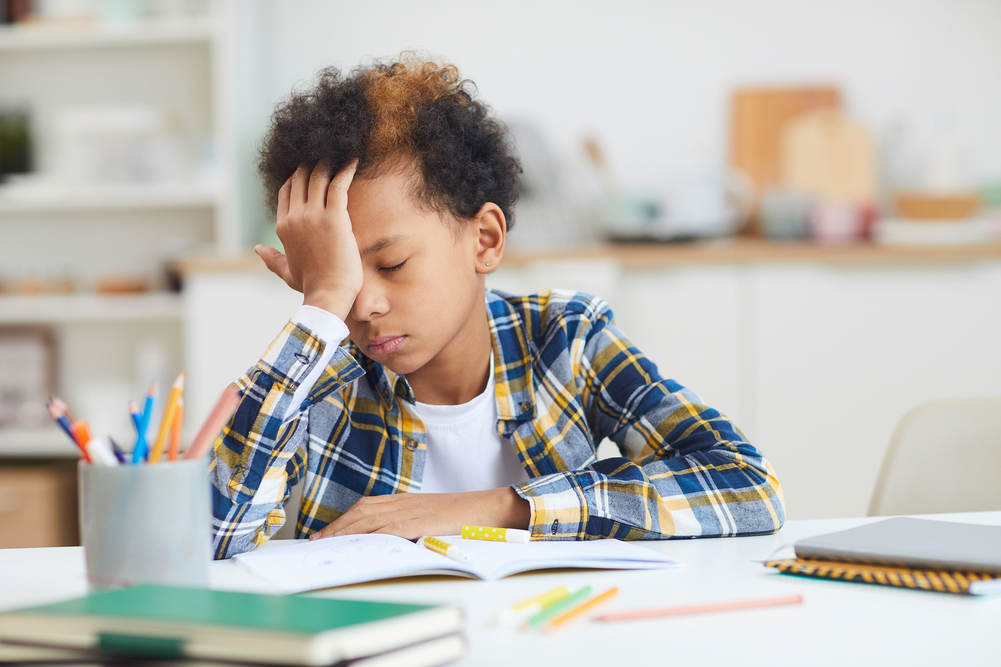 exhausted african boy doing homework