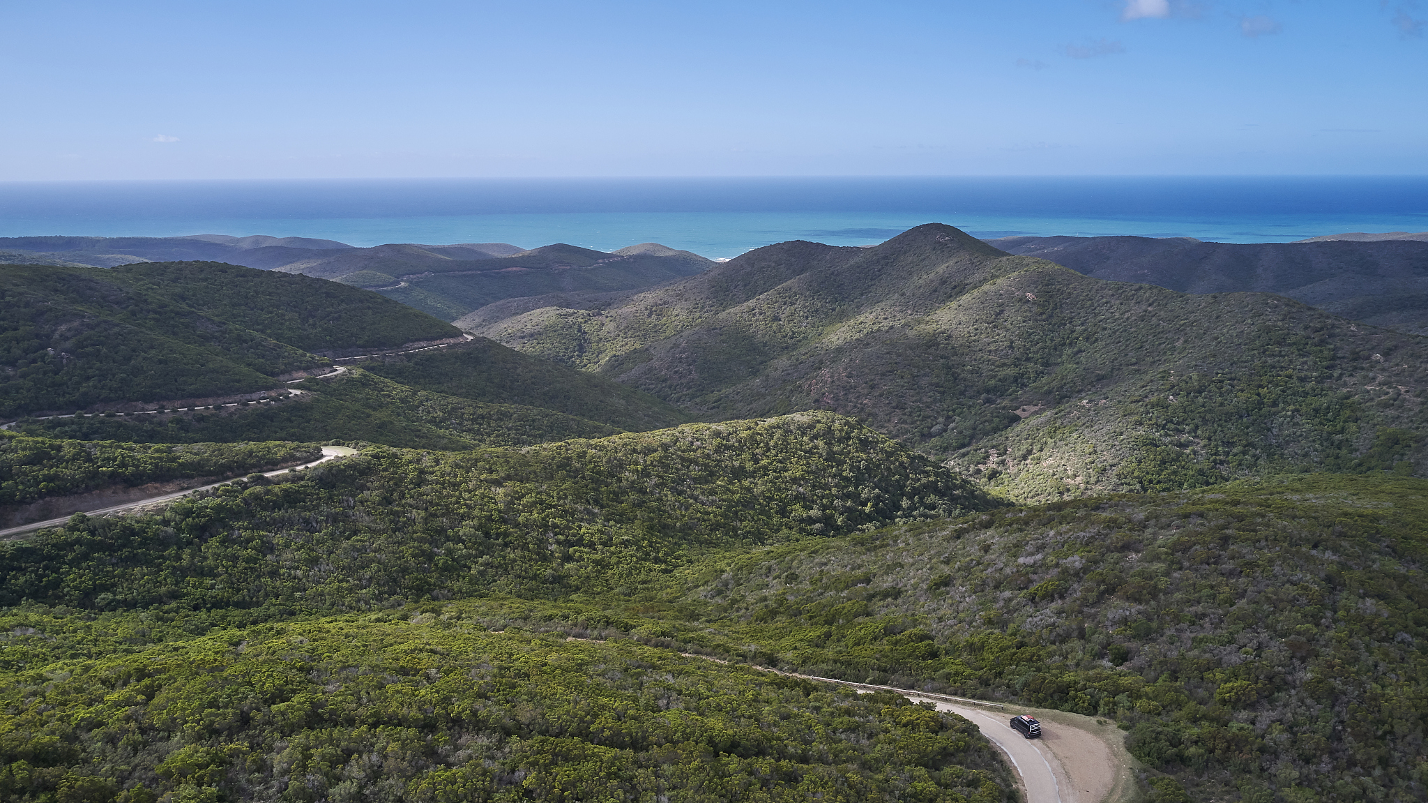 vw bus driving windy road in mountains of sardinia