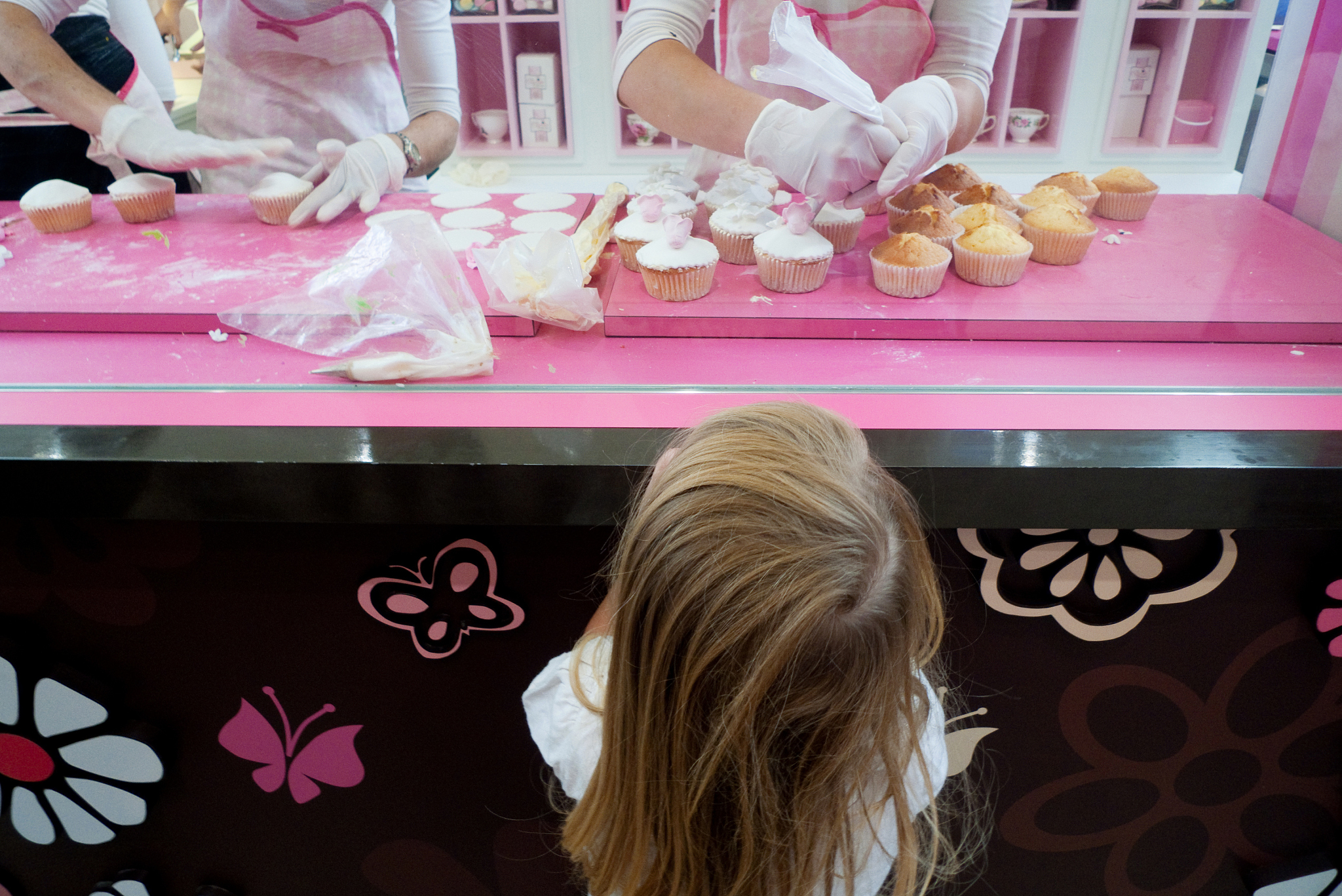 girl watching cupcakes