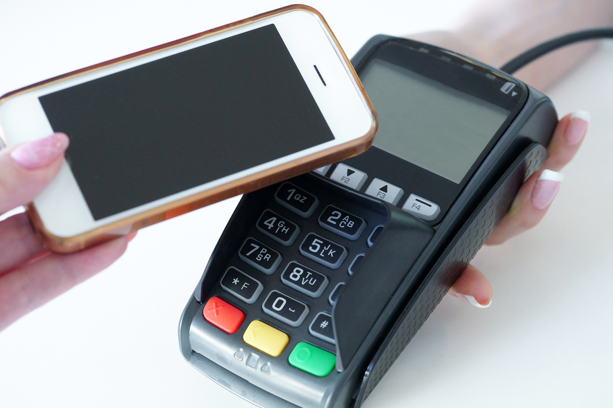woman puts a bank card into a reader, makes a purchase