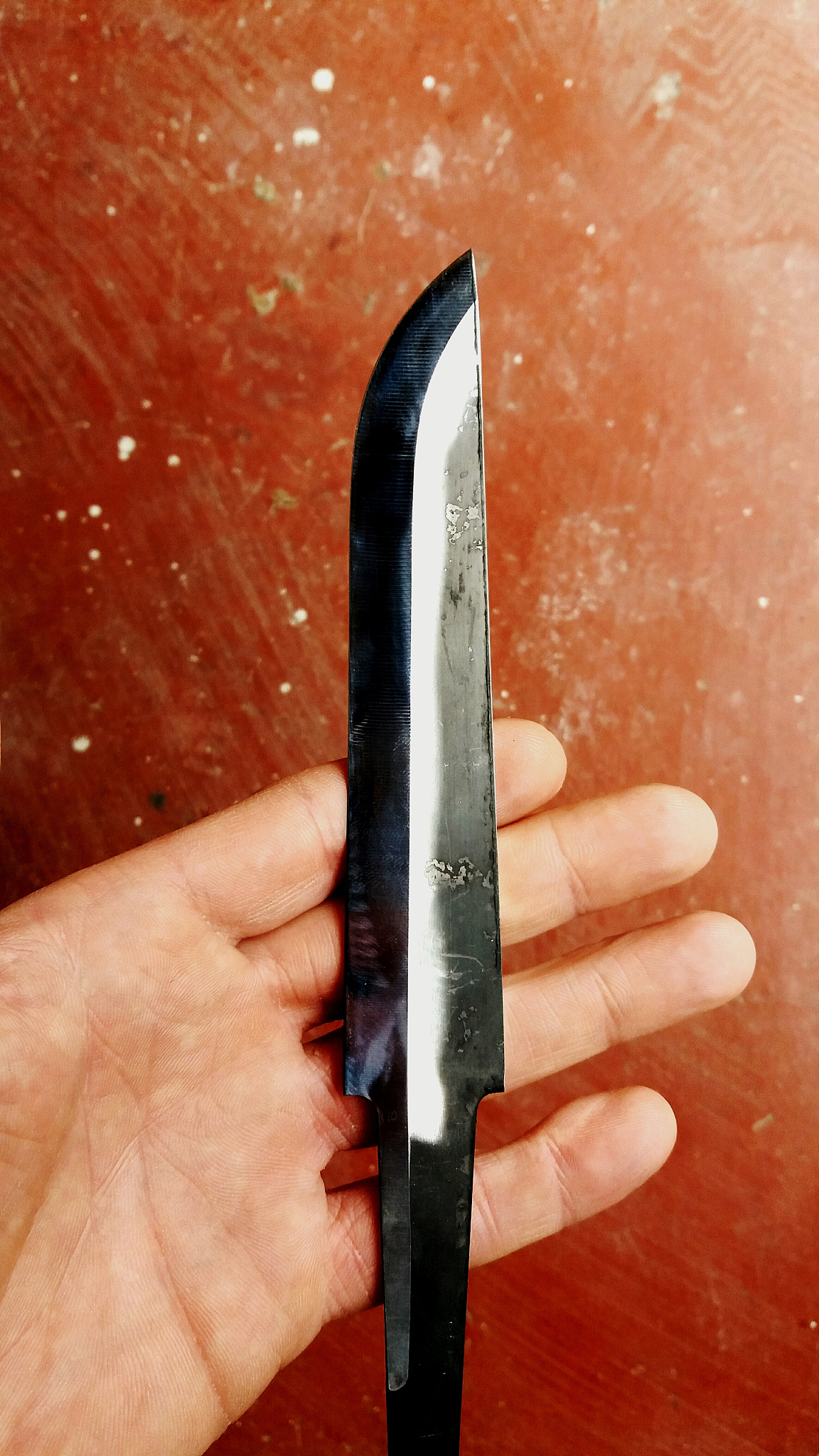 cropped image of hand holding knife over table