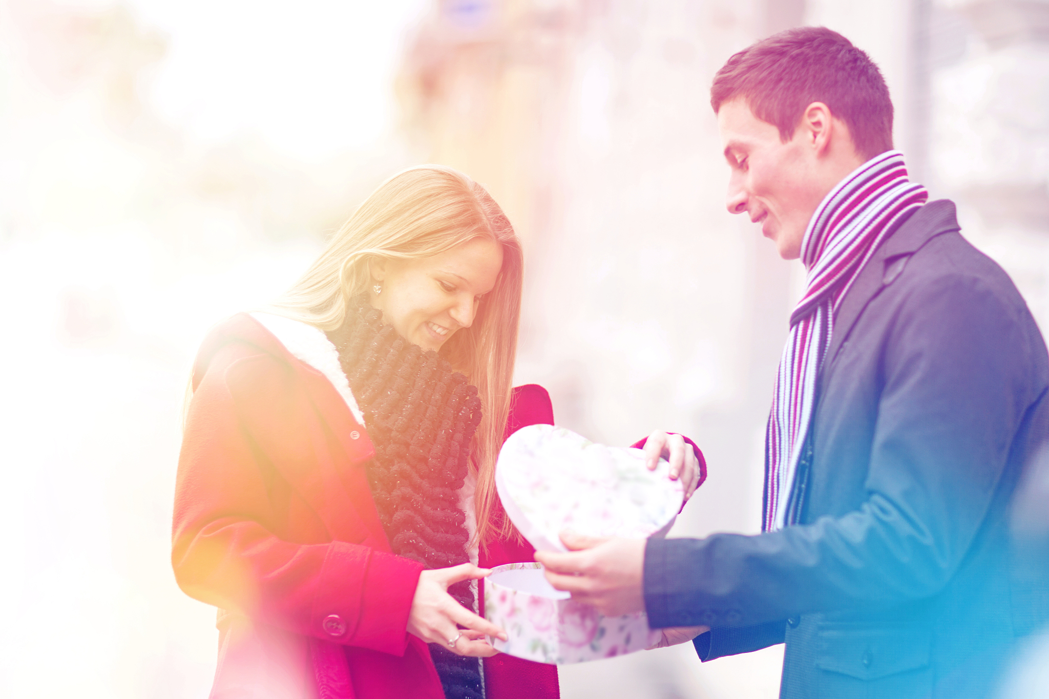 young couple celebrating valentines day with opening gift.