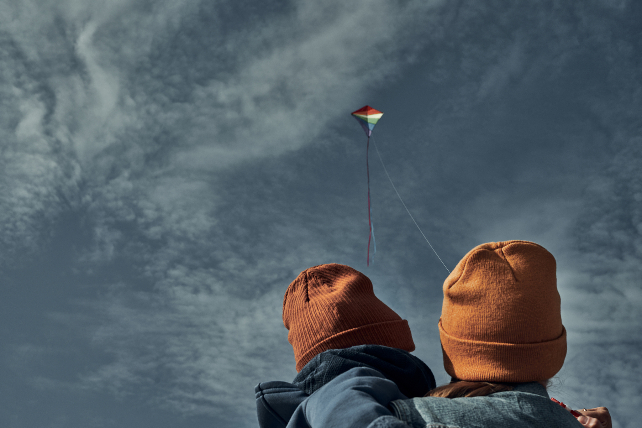 a woman with a two-year-old child is flying a kite. games with c